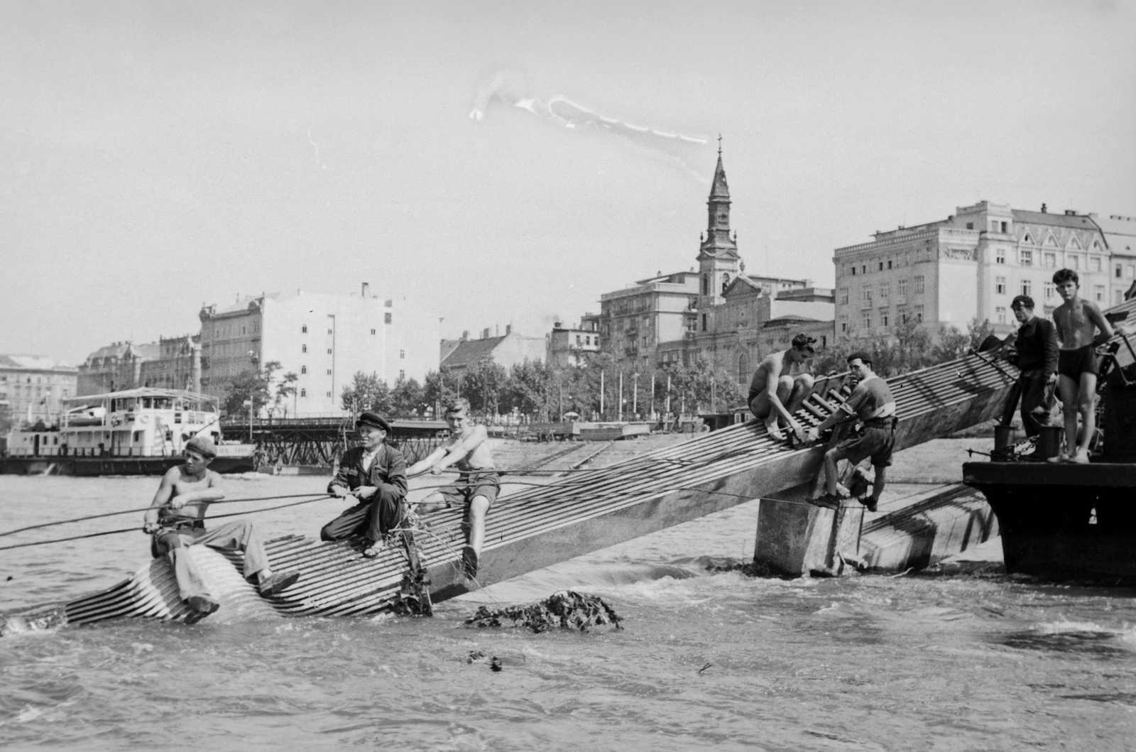 Hungary, Budapest V., az Erzsébet híd láncszerkezetének kiemelését végző munkások. Háttérben a Pesti szállodasor és a Petőfi tér az ortodox templommal., 1949, Kovács Márton Ernő, war damage, wrecked bridge, eclectic architecture, Budapest, suspension bridge, Duna-bridge, Antal Kherndl-design, Aurél Czekelius-design, Fortepan #33686