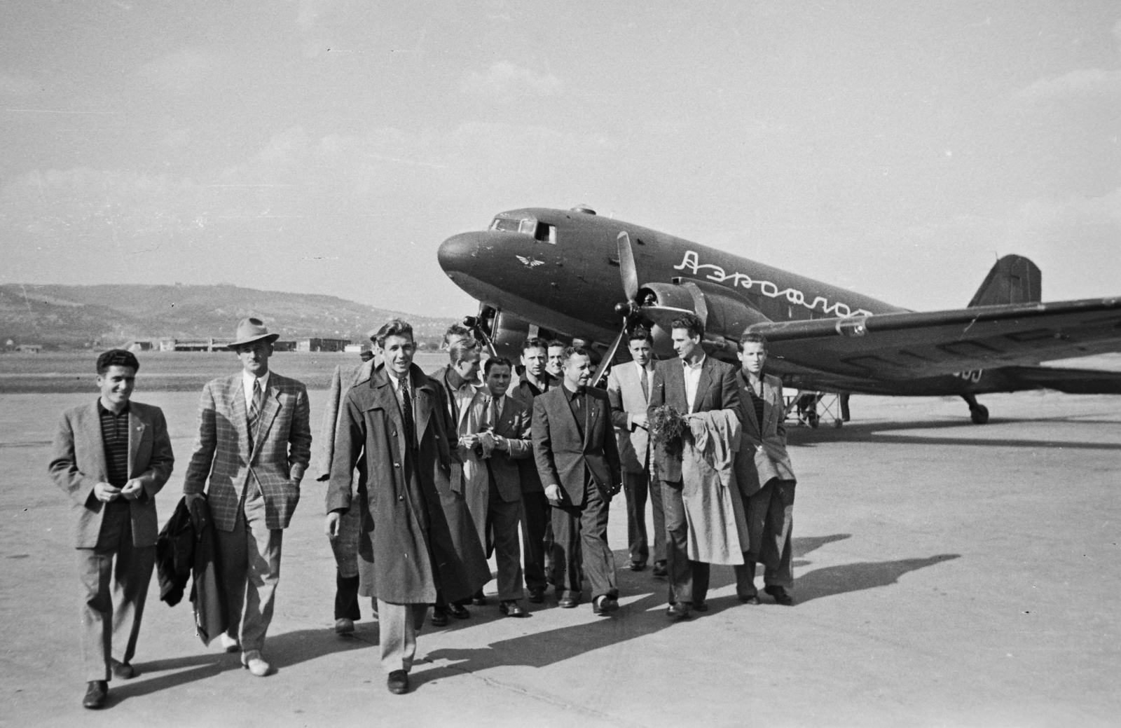 Hungary, Budaörs Airport, Budapest XI., a Vasas futballcsapata, balról a második, kalapban Lóránt Gyula, középen a második sorban, kihajtott gallérú, sötét ingben Illovszky Rudolf, jobbról a második Szilágyi I Gyula. A háttérben egy Douglas C-47 típusú típusú repülőgép., 1949, Kovács Márton Ernő, transport, Soviet brand, airplane, soccer team, airport, Lisunov-brand, Aeroflot airlines, Budapest, Cyrillic alphabet, Fortepan #33743