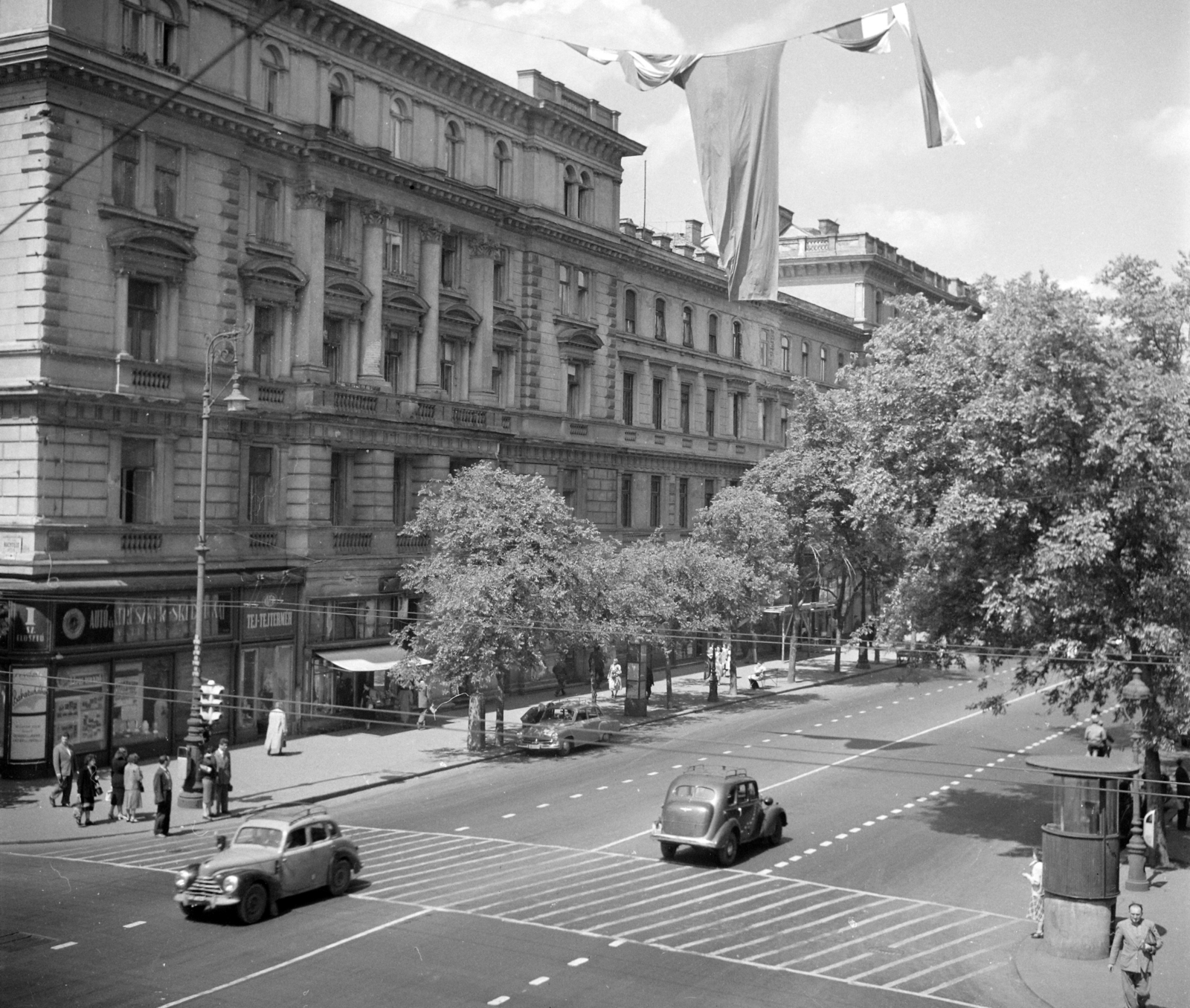 Hungary, Budapest VI., Andrássy út (Népköztársaság útja) a Nagymező utcától az Oktogon (November 7. tér) felé., 1957, UVATERV, traffic, sign-board, street view, genre painting, signal, crosswalk, taxicab, lamp post, untitled, dairy, Budapest, Fortepan #3586
