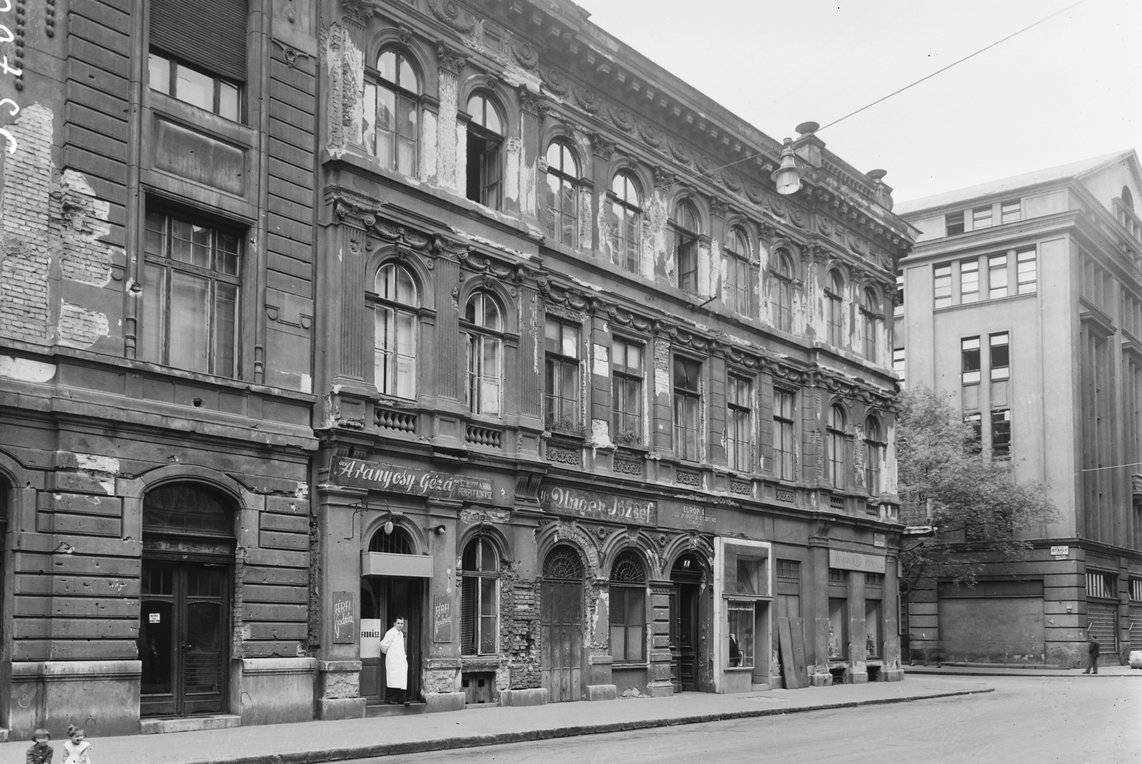 Magyarország, Budapest VIII., Somogyi Béla (Rökk Szilárd) utca 5., jobbra a Stáhly utca sarkán a Corvin Áruház épülete., 1957, UVATERV, cégtábla, utcakép, üzletportál, fodrászat, Budapest, Fortepan #3616