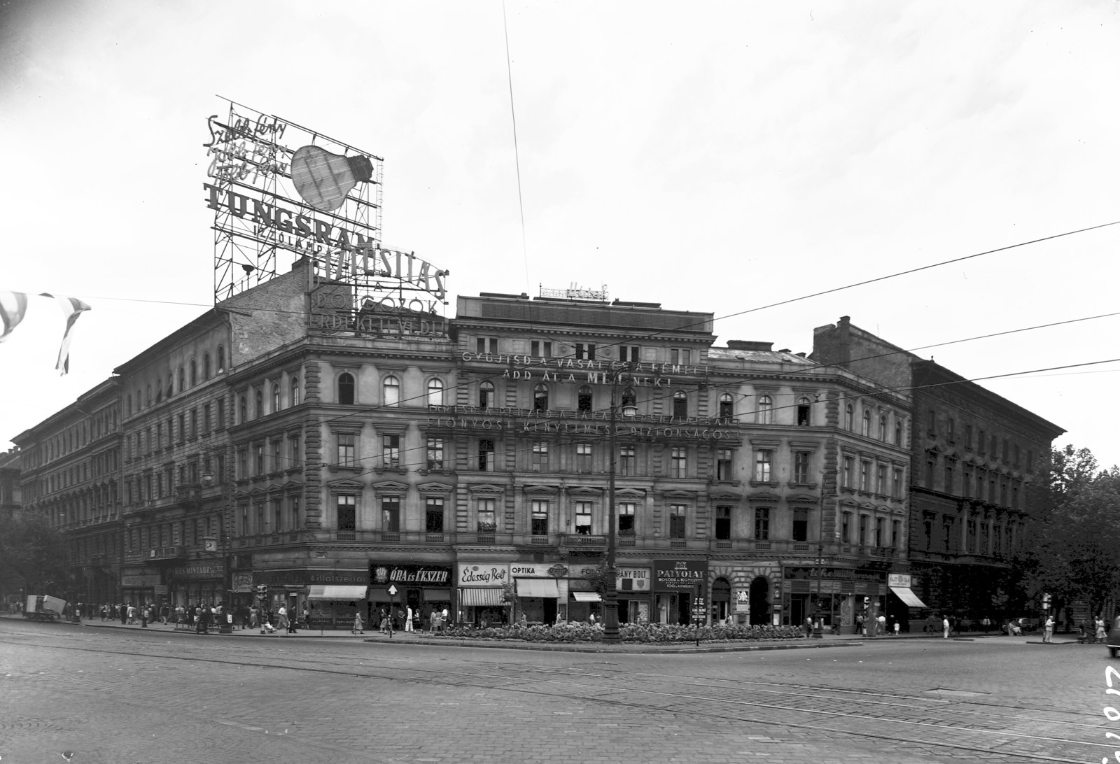 Hungary, Budapest VI., Oktogon (November 7. tér) szemben a 4-es számú ház, balra a Teréz (Lenin) körút, jobbra az Andrássy (Sztálin) út., 1954, UVATERV, sign-board, watch, street view, genre painting, neon sign, perfume store, watch jewelry store, candy store, Tungsram-brand, Budapest, Fortepan #3697