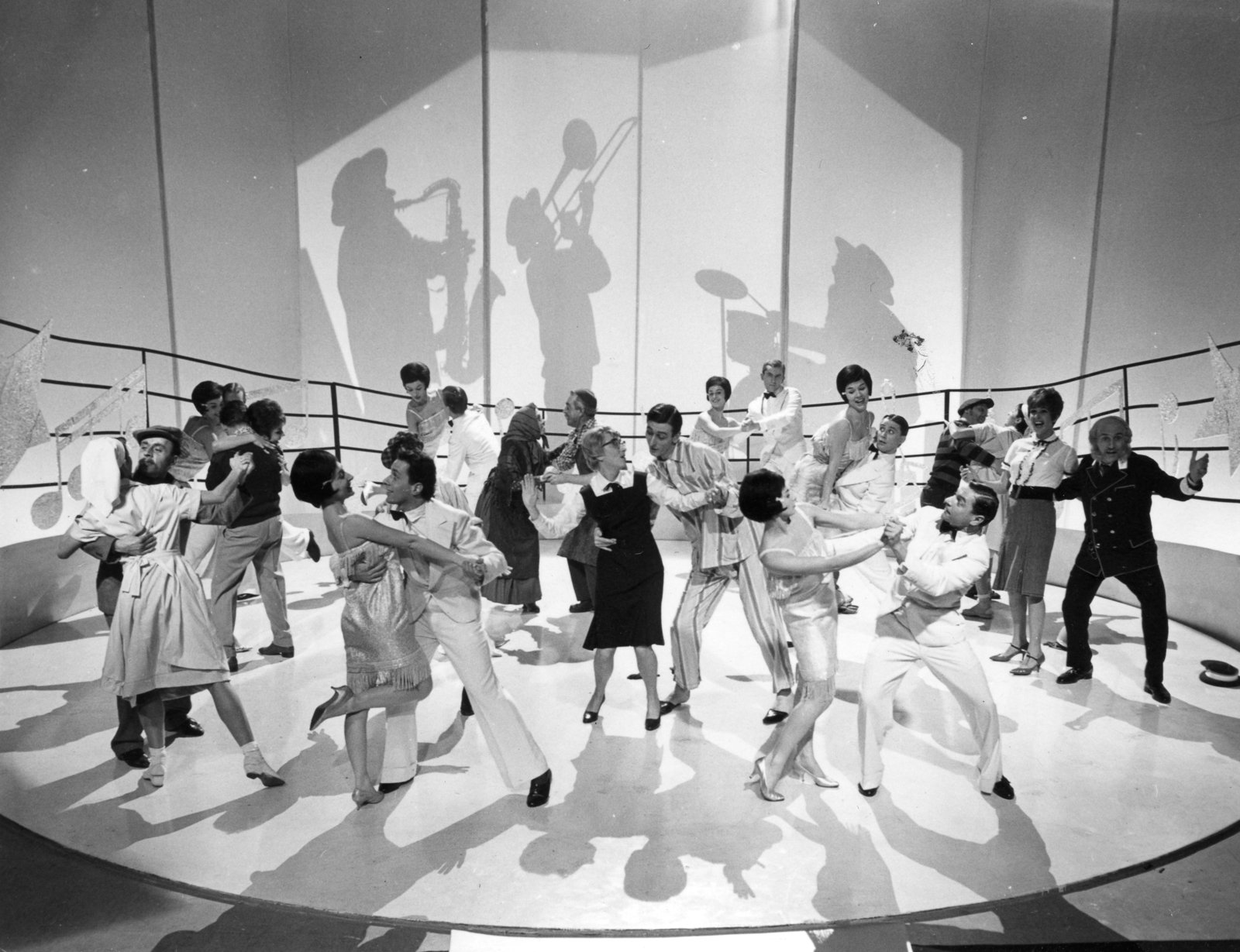 Hungary, jelenet az MTV 1963. szilveszteri műsorában sugározott, Slágermúzeum című revüfilmből. Balra, háttal, sötét pulóverben Bodrogi Gyula, vele táncol Lehoczky Zsuzsa, a jobb szélen Psota Irén és Alfonzó (Markos József) színművészek., 1963, Hangosfilm, art of theater, celebrity, fun, dance, band, shadow, silhouette, Fortepan #39225