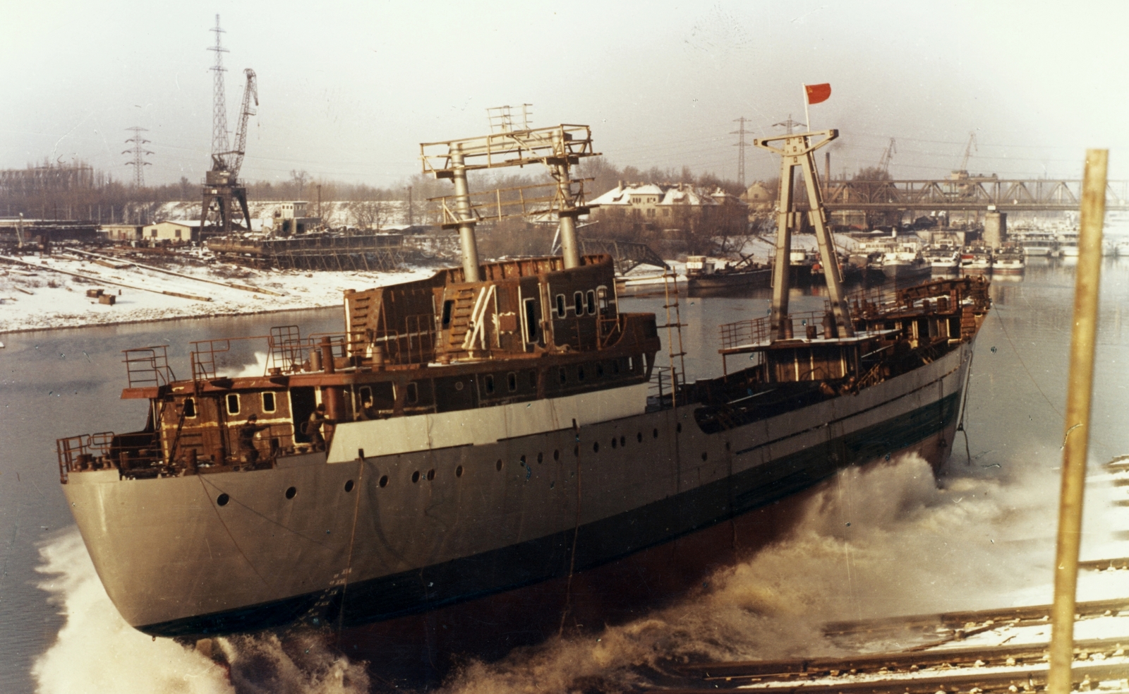 Hungary, Budapest XIII., Újpesti-öböl, a Magyar Hajó- és Darugyár Angyalföldi Gyáregysége, Tartu típusú tengeri áruszállító hajó vízre bocsátása., 1967, Angyalföldi Helytörténeti Gyűjtemény, ship, colorful, flag, crane, shipbuilding industry, boatyard, Budapest, Fortepan #39617