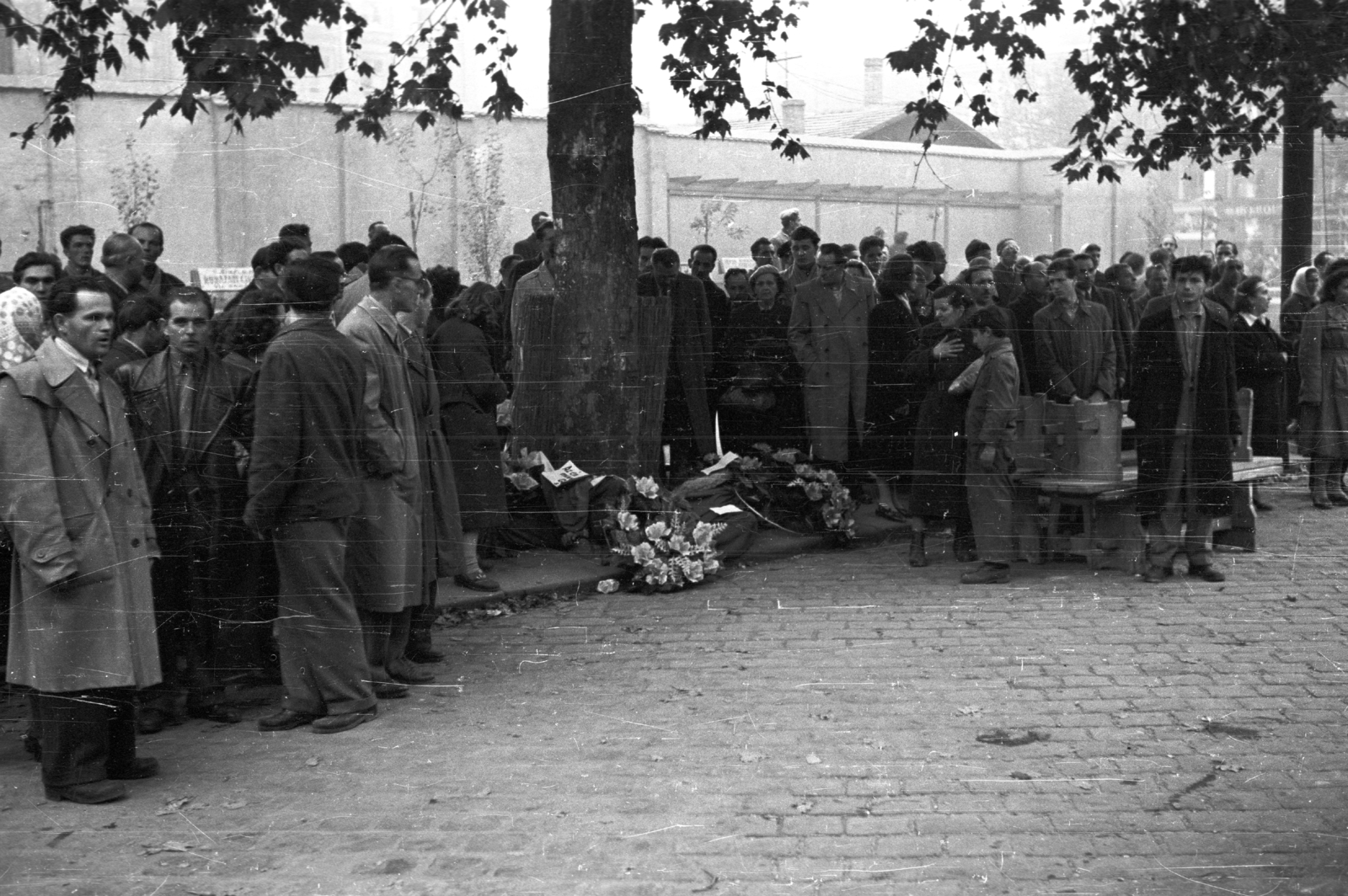 Hungary, Budapest VIII., Rákóczi út, metró építkezés kerítése, háttérben a Múzeum körút házai., 1956, Nagy Gyula, mass, revolution, wreath, Budapest, Fortepan #39797