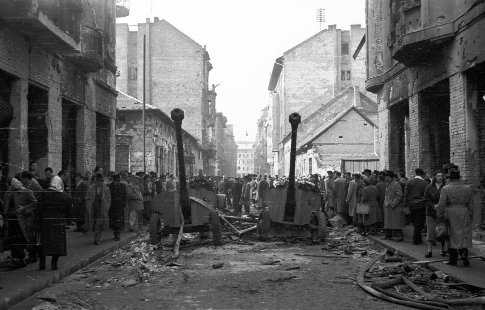 Magyarország, Budapest VIII., Práter utca a József körút felé nézve. 85 mm-es páncéltörő ágyúk a Futó utcai kereszteződésnél., 1956, Nagy Gyula, háborús kár, tömeg, forradalom, fegyver, Budapest, páncéltörő ágyú, Uralmash D-44, Fortepan #39841