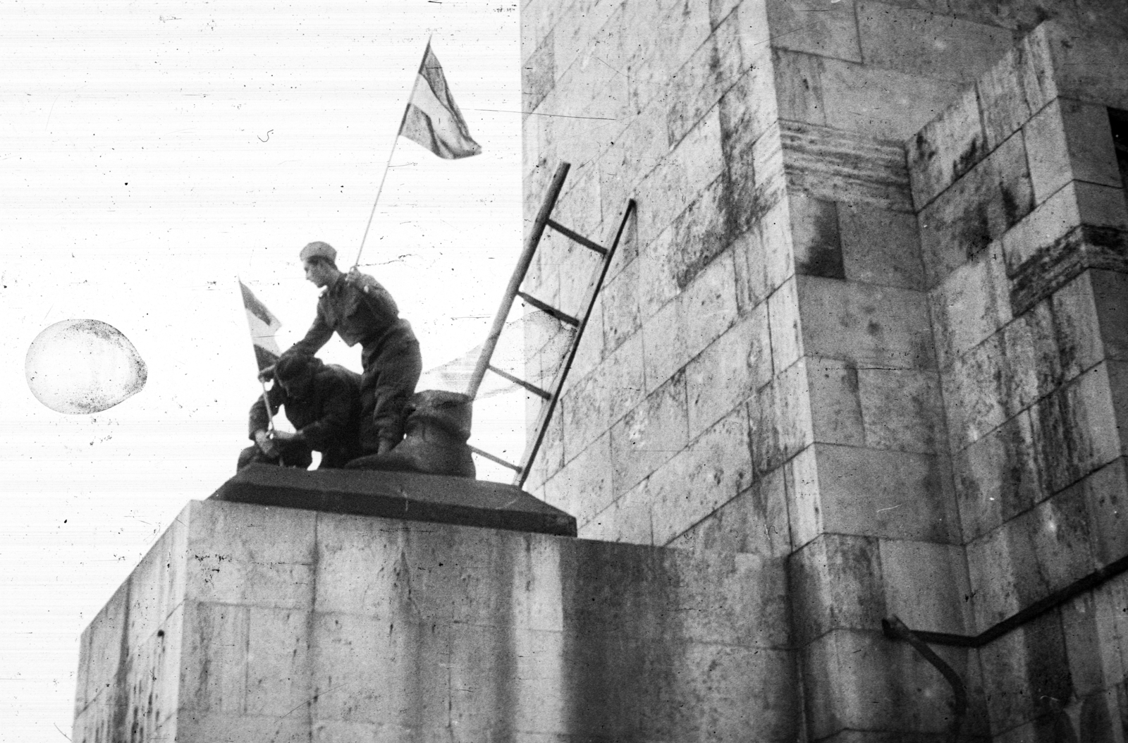 Hungary, Budapest XI., a Felszabadulási Emlékmű (Kisfaludi Strobl Zsigmond) "Felszabadító szovjet katona" mellékalakjának ledöntése után a szobor ottmaradt csizmájához köti a zászlót egy kiskatona segítségével Mikó József operatőr., 1956, Nagy Gyula, flag, revolution, sculpture, destruction of symbols, Budapest, standing on a sculpture, Fortepan #39861