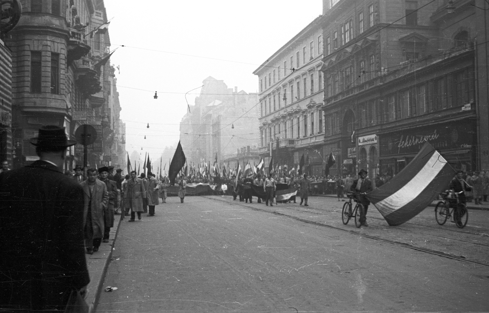 Hungary, Budapest V., Kossuth Lajos utca az Astoria felé nézve. 1956. október 25-e délután, "véres-zászlós" tüntetés., 1956, Nagy Gyula, bicycle, flag, sign-board, mass, revolution, street view, march, Budapest, Fortepan #39946