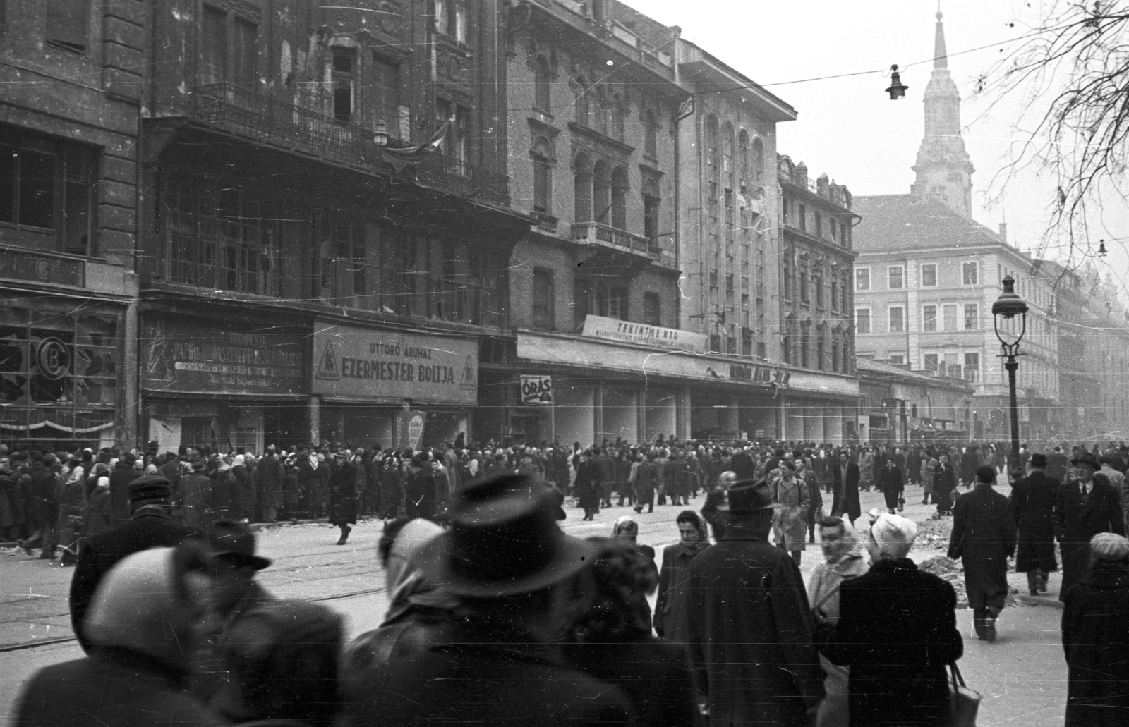 Hungary, Budapest V., Kossuth Lajos utca a Semmelweis utca felől a Ferenciek tere (Felszabadulás tér) felé nézve., 1956, Nagy Gyula, war damage, sign-board, mass, revolution, pedestrian, street view, lamp post, store, store display, Budapest, Fortepan #39965