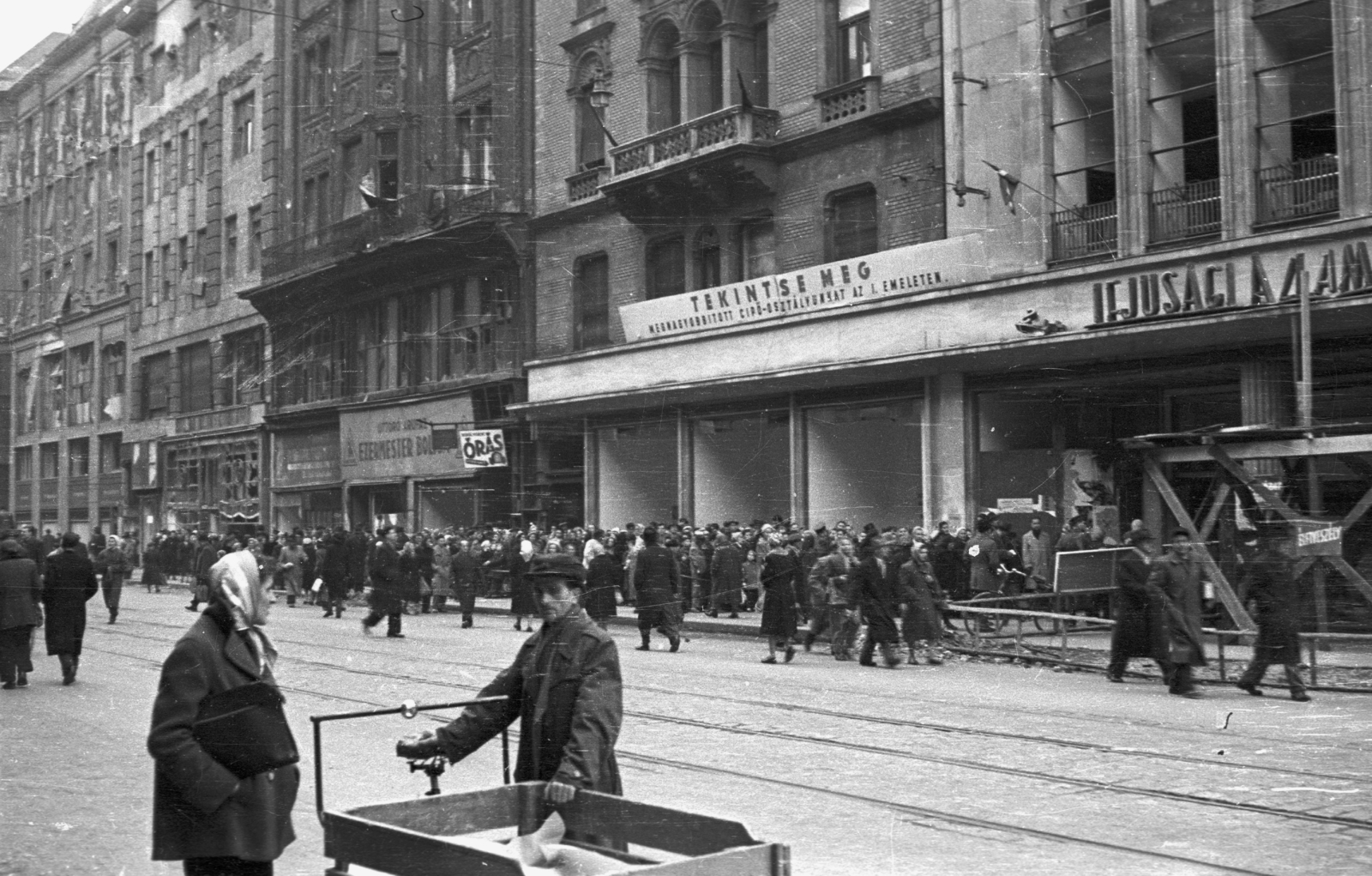 Hungary, Budapest V., Kossuth Lajos utca, szemben az Úttörő Áruház., 1956, Nagy Gyula, war damage, sign-board, label, revolution, pedestrian, street view, store, store display, standing in line, Budapest, Fortepan #39969