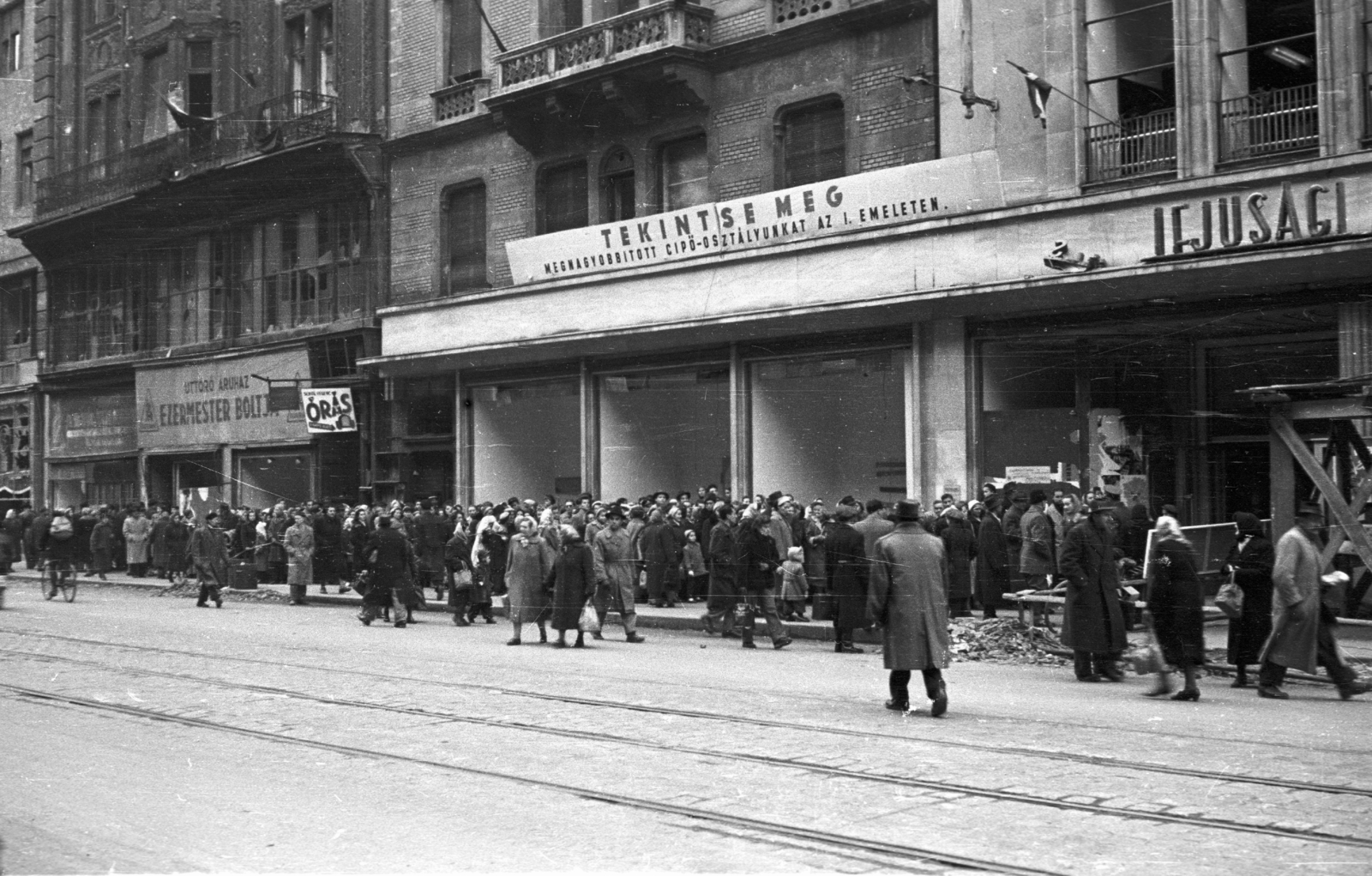 Hungary, Budapest V., Kossuth Lajos utca, szemben az Úttörő Áruház., 1956, Nagy Gyula, war damage, sign-board, mass, label, revolution, pedestrian, street view, store display, standing in line, Budapest, Fortepan #39970