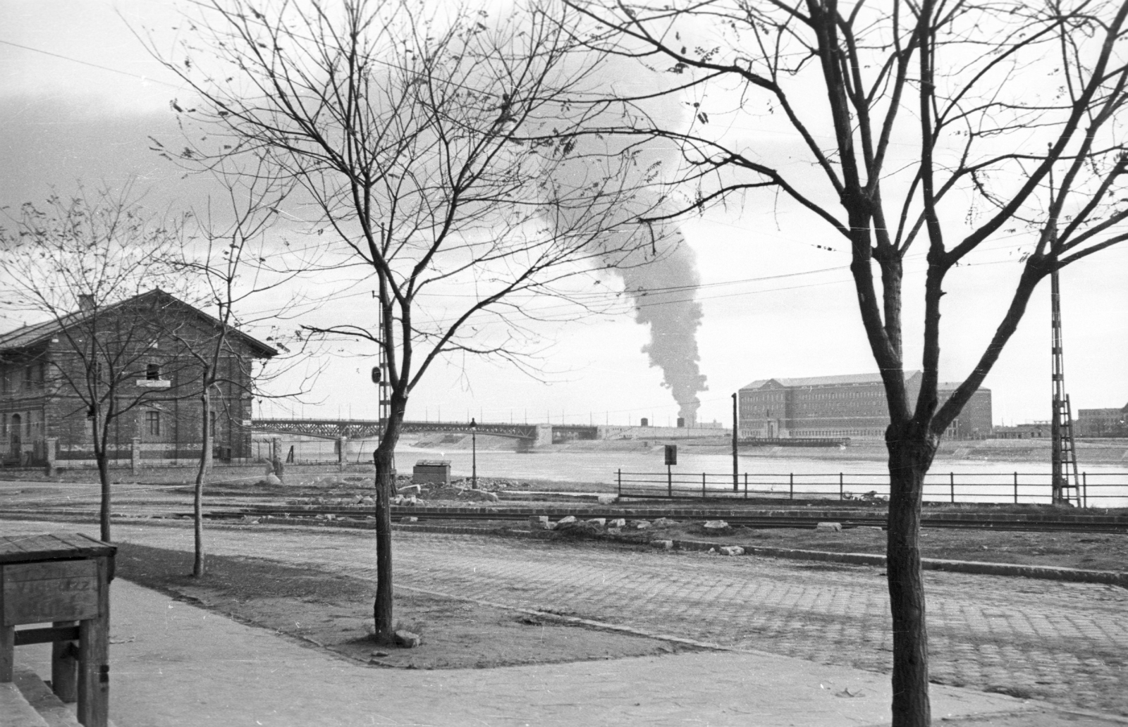 Hungary, Budapest IX., Fővám (Dimitrov) tér egyetem előtti része, balra a közraktárak, háttérben a Petőfi híd., 1956, Nagy Gyula, bridge, university, smoke, Danube, warehouse, Budapest, Duna-bridge, Hubert Pál Álgyay-design, Fortepan #40007
