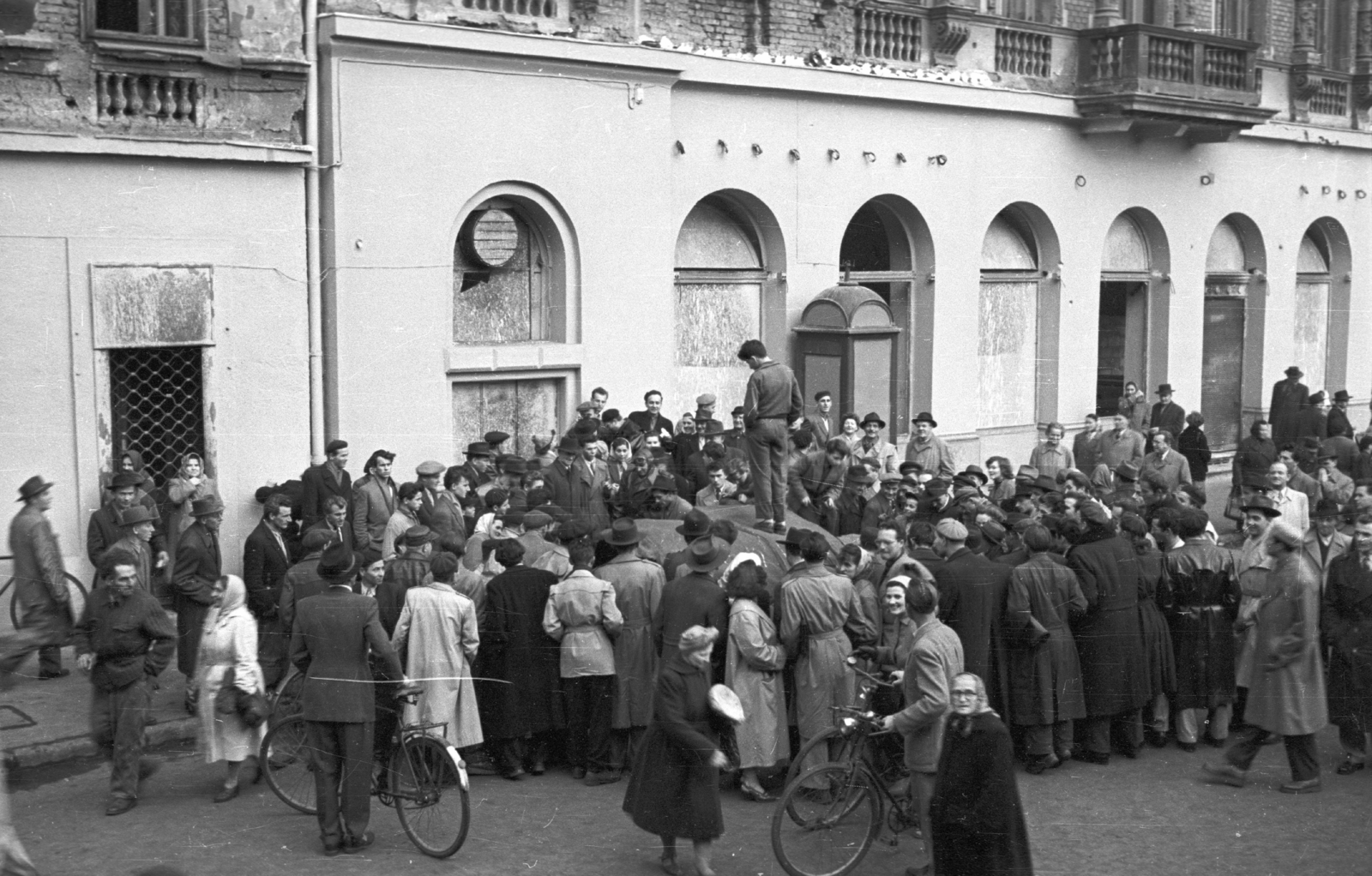 Magyarország, Budapest VII., Akácfa utca Rákóczi út felé nézve, folyik a Sztálin szobor szétdarabolása., 1956, Nagy Gyula, kerékpár, tömeg, forradalom, szobor, telefonfülke, jelképrombolás, Sztálin ábrázolás, Budapest, szobron áll, Fortepan #40136