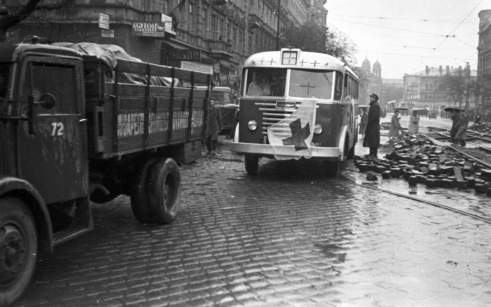 Magyarország, Budapest V., Szent István körút a Visegrádi utcától a Nyugati (Marx) tér felé nézve., 1956, Nagy Gyula, autóbusz, zászló, forradalom, magyar gyártmány, teherautó, utcakép, életkép, Ikarus-márka, Csepel-márka, esernyő, kockakő, vöröskereszt, Ikarus 60, Budapest, Fortepan #40234