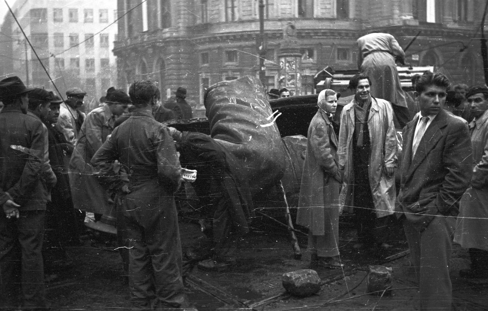 Hungary, Budapest VIII.,Budapest VII., Rákóczi út - Nagykörút kereszteződés, háttérben a Nemzeti Színház. Folyik a Sztálin szobor feldarabolása., 1956, Nagy Gyula, revolution, national theater, sculpture, Fellner and Helmer-design, destruction of symbols, Joseph Stalin portrayal, eclectic architecture, Budapest, standing on a sculpture, Fortepan #40275