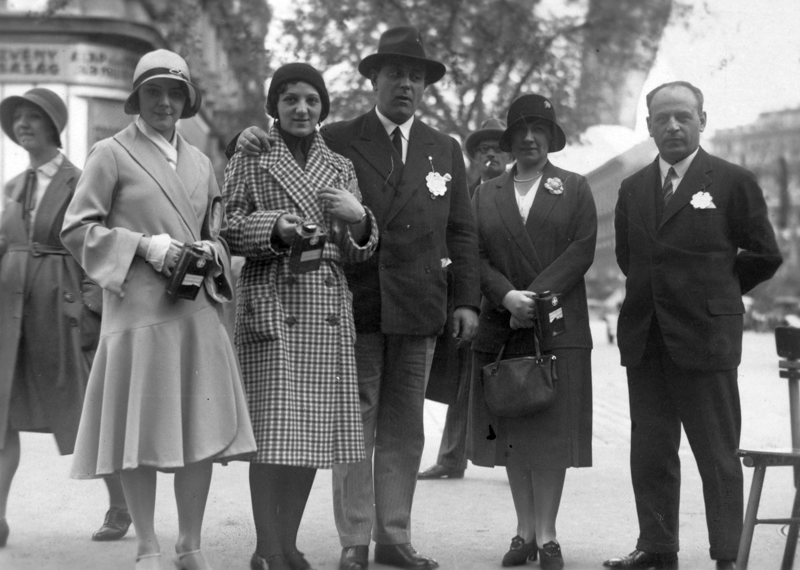 Hungary, Budapest VI., Andrássy út a Jókai térnél, háttérben az Oktogon házai. Az Operaház társulatának tagjai adományokat gyűjtenek az Országos Gyermekvédő Liga számára. Középen kalapban Székely Mihály operaénekes, balra Vera Ilona (kockás kabátban) táncosnő, mellette Szalay Karola balett-táncos, jobb szélen Somló József operaénekes., 1933, SK, art of theater, charity, money-box, Budapest, hands behind the back, arms around shoulders, Fortepan #40943