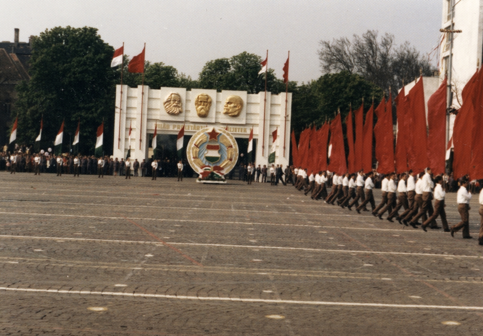Magyarország, Budapest XIV., Ötvenhatosok tere (Felvonulási tér), szemben a Városligeti (Gorkij) fasor, május 1-i felvonulás., 1980, Angyalföldi Helytörténeti Gyűjtemény, színes, zászló, Lenin-ábrázolás, felvonulás, május 1, címer, Karl Marx-ábrázolás, Budapest, pódiumautó, Fortepan #41323