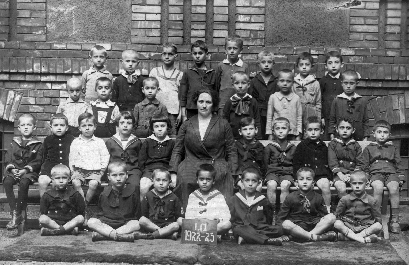 Magyarország, Budapest XIII., Radnóti Miklós (Sziget) utca 8-10, a mai Gárdonyi Géza Általános Iskola udvara., 1922, Angyalföldi Helytörténeti Gyűjtemény, iskola, osztálykép, csoportkép, tanár, tornaszőnyeg, Budapest, ülés keresztbe tett lábakkal, Fortepan #41425