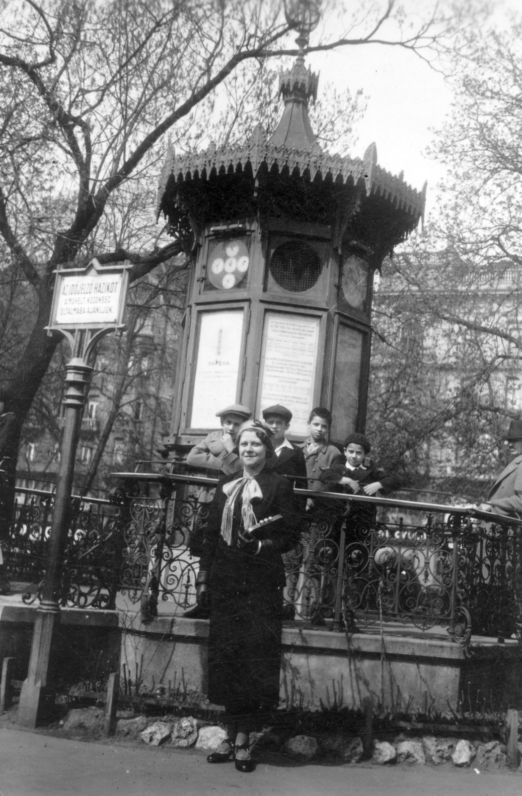 Magyarország, Budapest V., Erzsébet tér, időjelző házikó, mögötte a József Attila (gróf Tisza István) utca házai a Sas utcánál., 1932, Székelyi Péter, csoportkép, időjárásjelző házikó, Budapest, Fortepan #41484