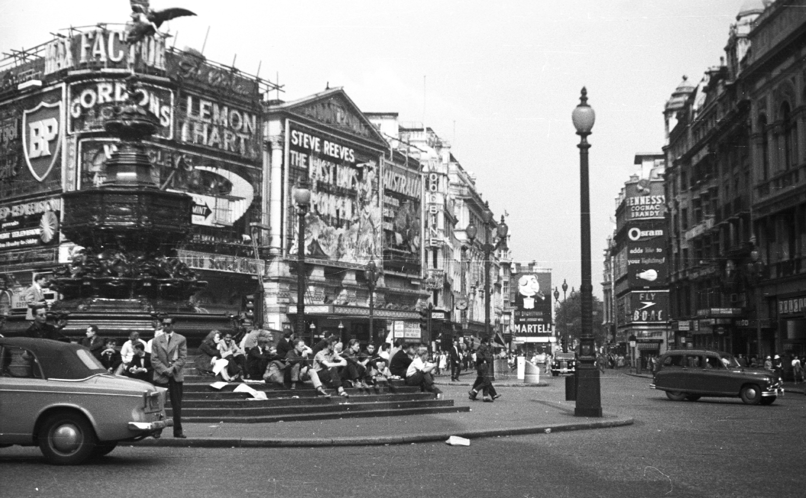 United Kingdom, London, Piccadilly Circus, a Coventry street felé nézve, Shaftesbury Memorial Fountain., 1959, MZSL/Ofner Károly, ad, excursion, traffic, sign-board, British brand, sculpture, street view, genre painting, stairs, lamp post, automobile, BP-brand, Fortepan #41921