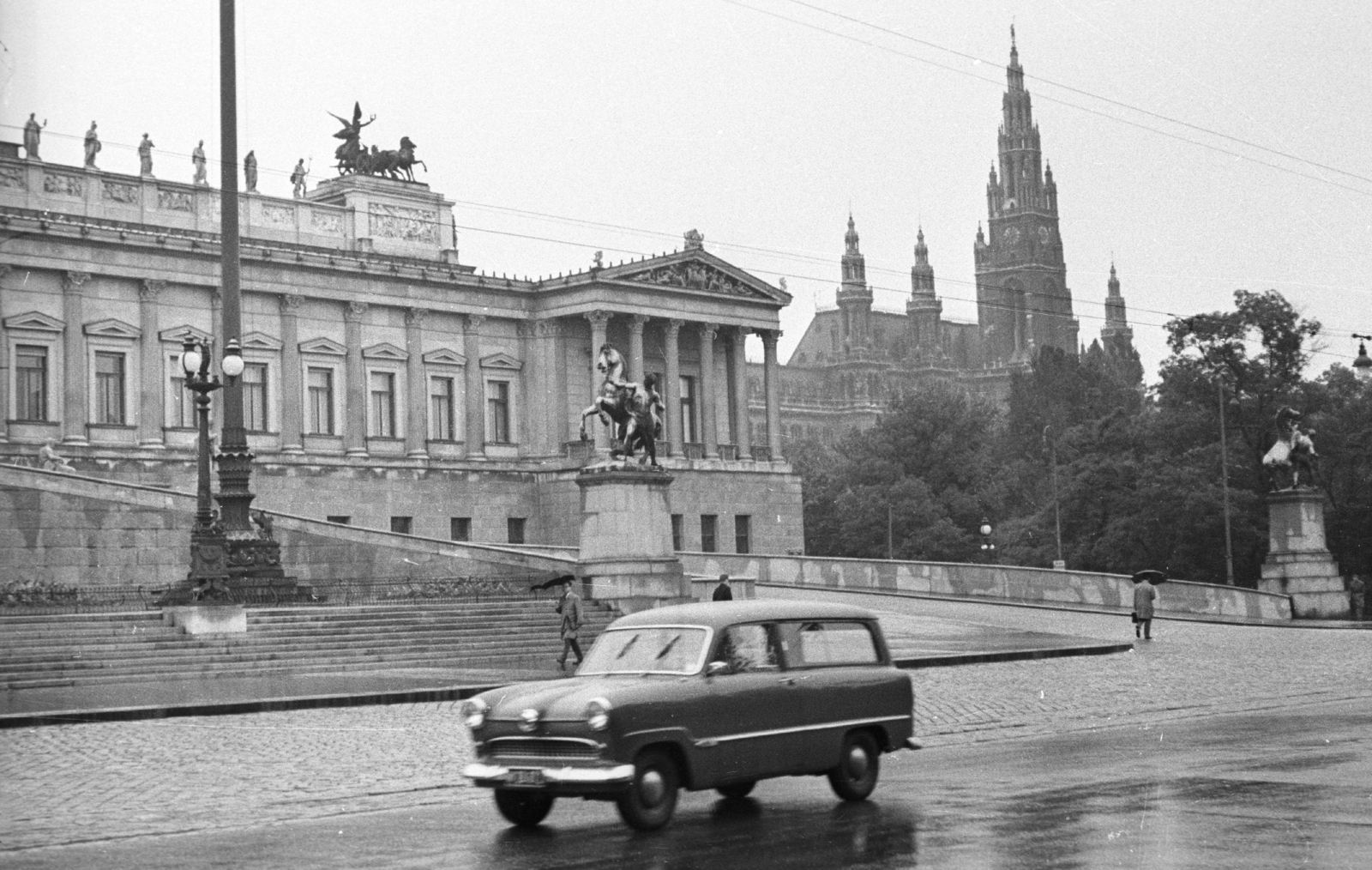 Austria, Vienna, Dr. Karl Renner-Ring, balra a Parlament, jobbra a Városháza., 1959, MZSL/Ofner Károly, street view, umbrella, cobblestones, parliament, automobile, rain, horse sculpture, Neoclassical architecture, horse-breaker portrayal, Theophil Hansen-design, Fortepan #42054
