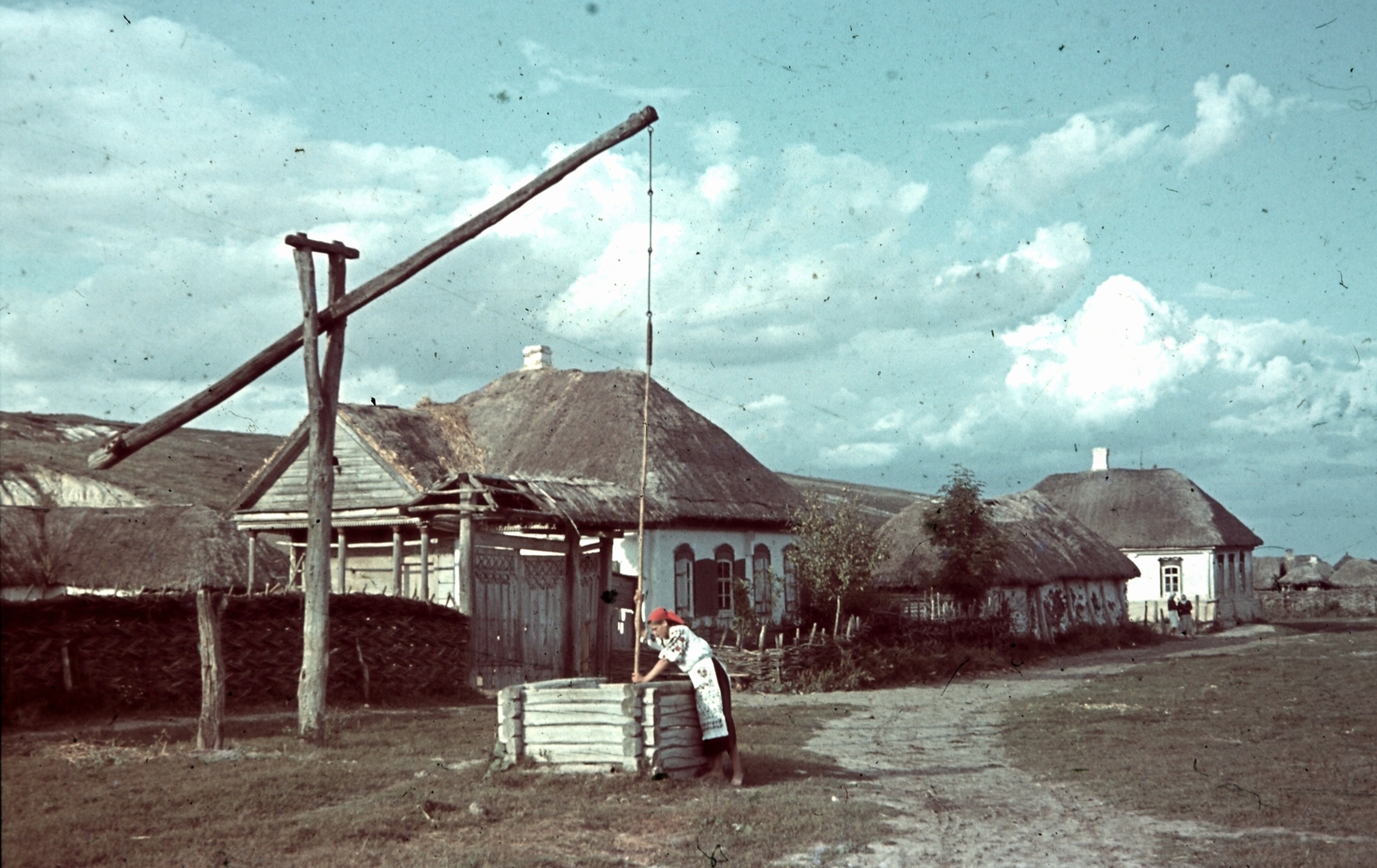 Oroszország, Koltunovka, 1942, Konok Tamás id, falu, színes, kút, népviselet, gémeskút, fonott kerítés, Fortepan #42695