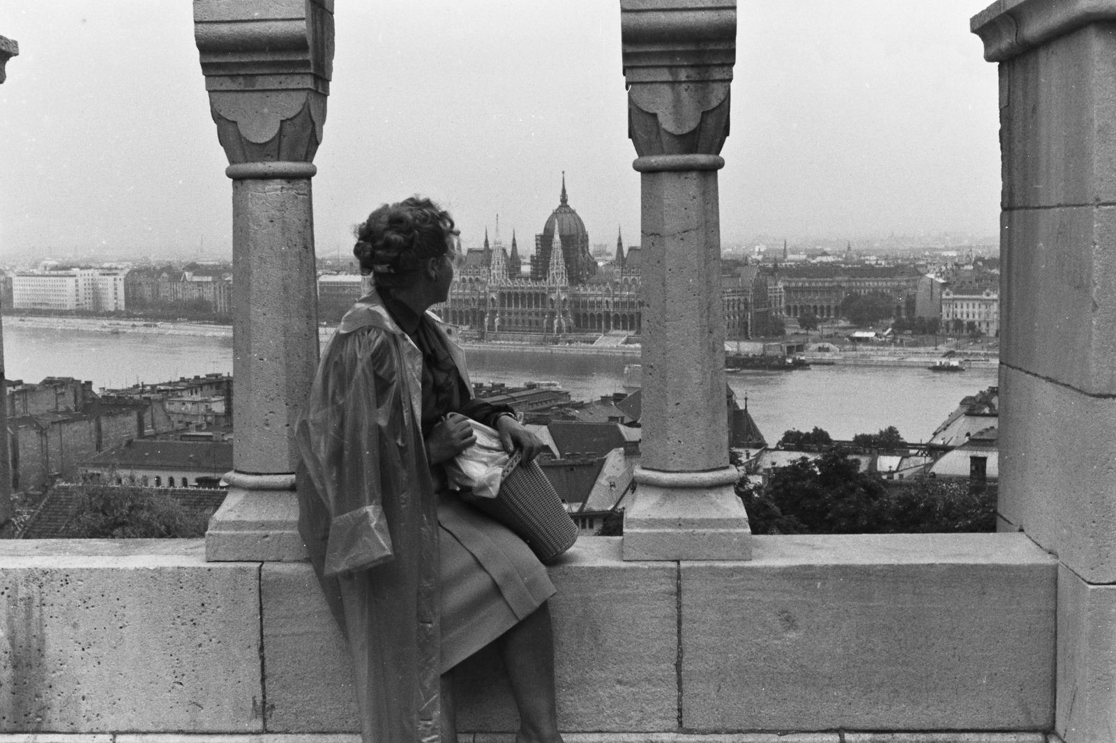Magyarország, Halászbástya,budai Vár, Budapest I., kilátás a Parlament felé., 1960, Konok Tamás id, Schulek Frigyes-terv, esőkabát, Steindl Imre-terv, nő, országház, neogótika, Duna, eklektikus építészet, Budapest, korláton ülni, Fortepan #42835