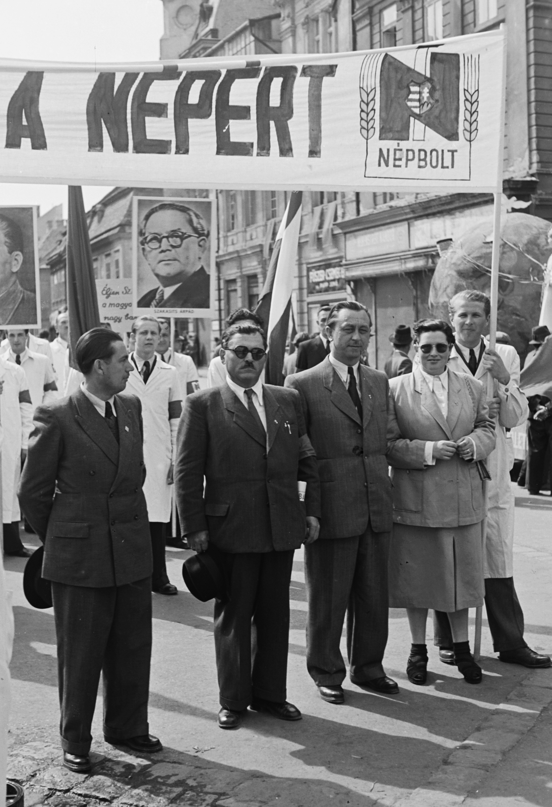 Hungary, Győr, Széchenyi tér, háttérben a Czuczor Gergely utca és a Kazinczy utca találkozása. A Népbolt dolgozói a május 1-i felvonuláson., 1949, Konok Tamás id, march, crest, Kossuth coat of arms, Fortepan #43041