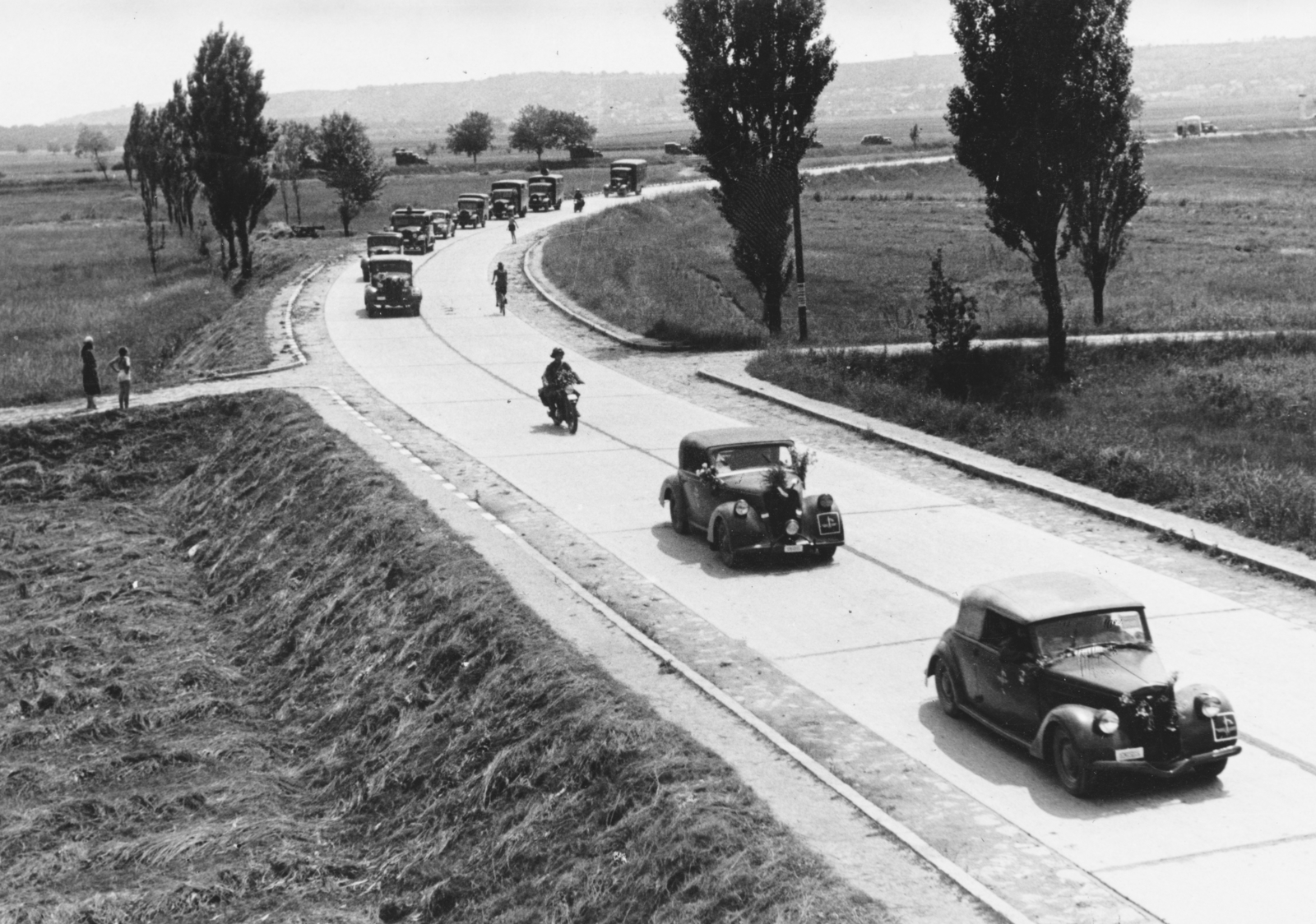 Hungary, Érd, a Balatoni út az Érd alsó-Tétényliget közötti vasúti töltésről nézve, háttérben keresztben a 6-os főút. A Magyar Királyi Haditudósító század gépkocsi menetoszlopa,, 1942, Konok Tamás id, military, landscape, automobile, Fortepan #43783