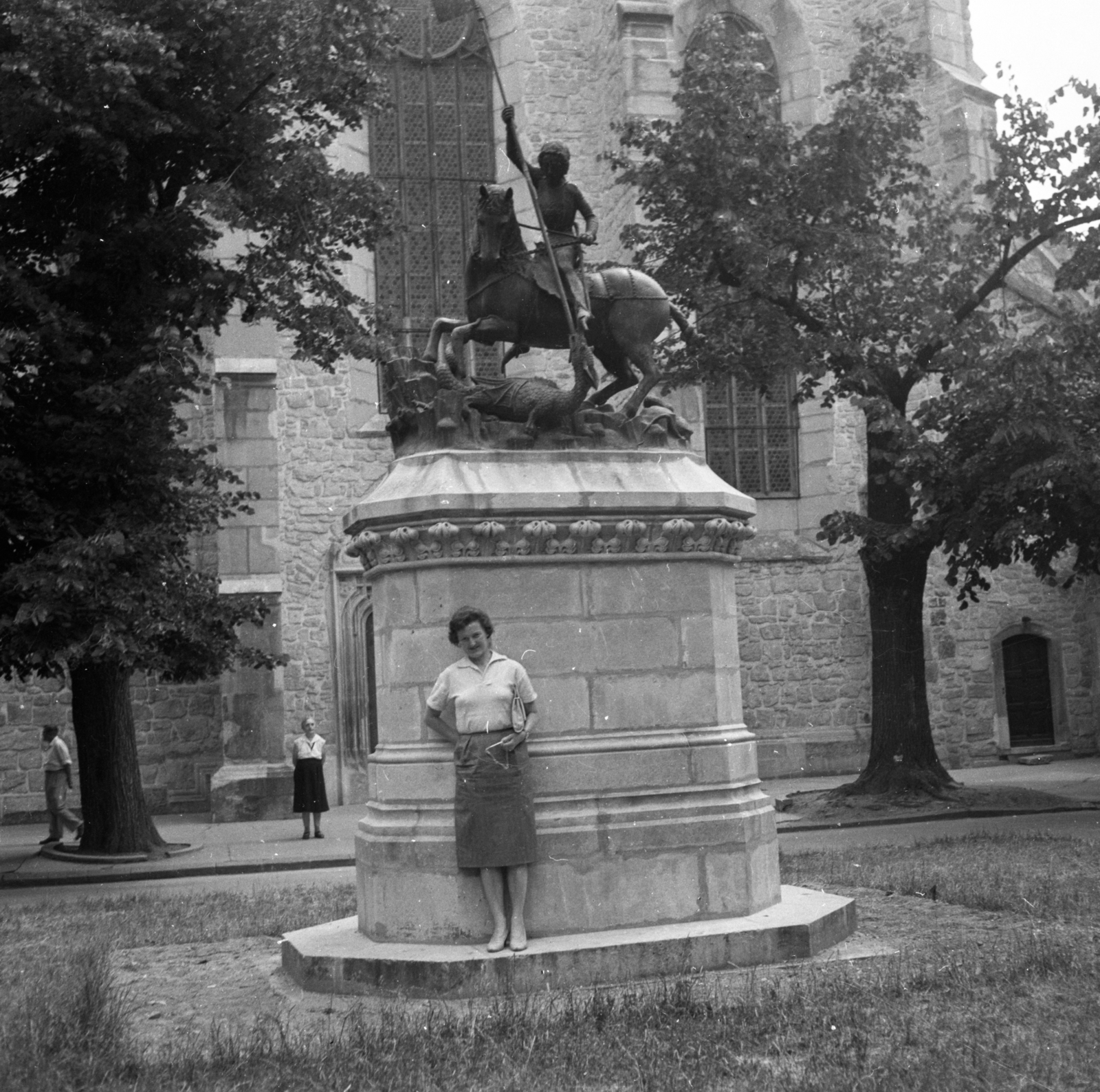 Romania,Transylvania, Cluj-Napoca, Farkas utca (Strada Mihail Kogălniceanu), a református templom előtt a Kolozsvári-fivérek prágai Sárkányölő Szent György szobrának másolata., 1961, Gyöngyi, portrait, lady, skirt, horse sculpture, dragon portrayal, blouse, Saint George-portrayal, Fortepan #44208