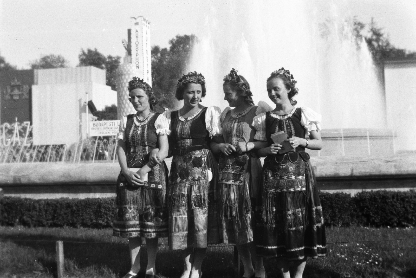 Magyarország, Városliget,Budapesti Nemzetközi Vásár, Budapest XIV., háttérben az Autosyphon pavilon., 1937, Korenchy László, szökőkút, csoportkép, nemzetközi vásár, népviselet, hölgy, Budapest, kart karba öltve, beöltözés, Fortepan #44519