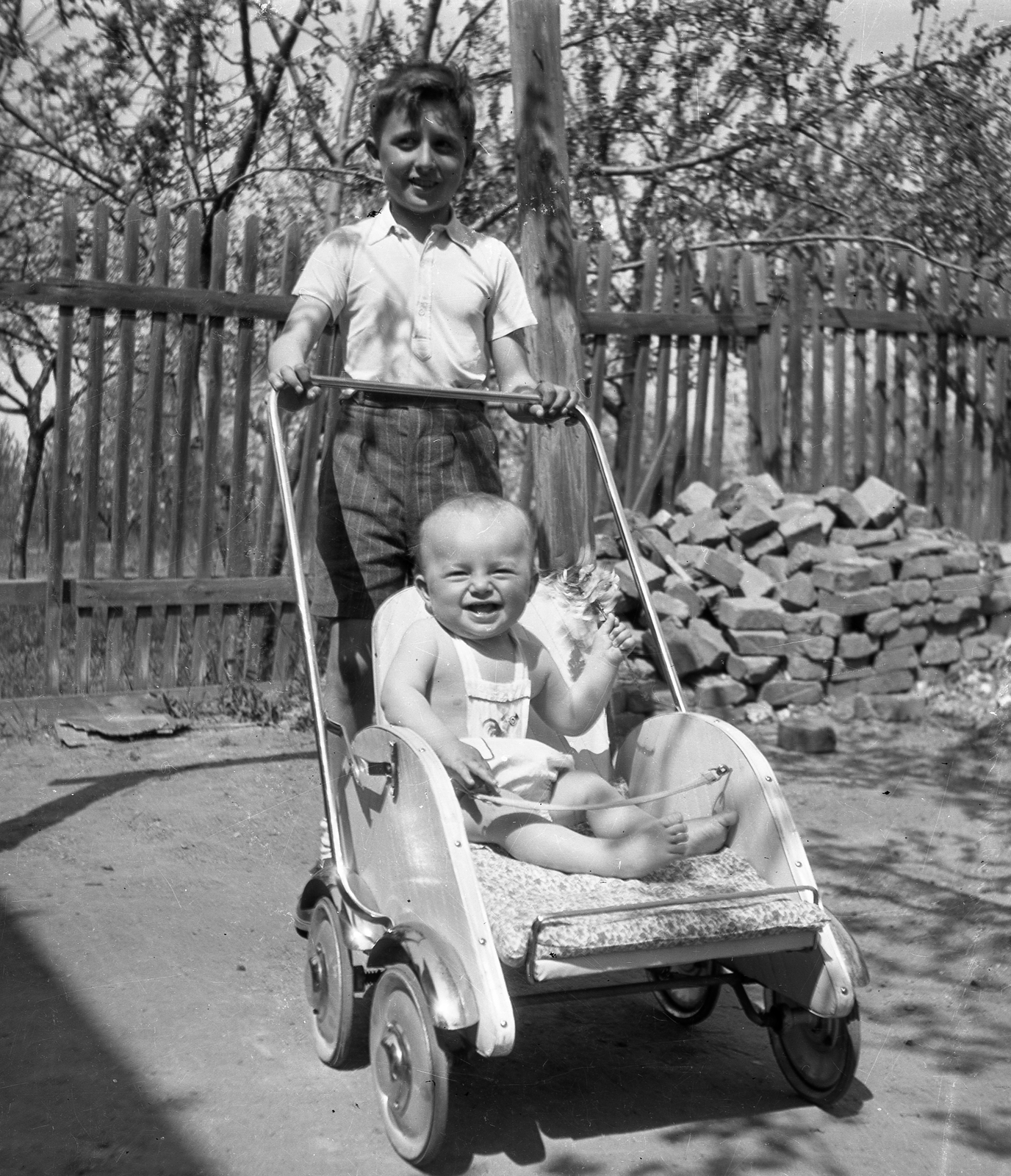 Hungary, Érd, Érdliget., 1955, Korenchy László, teenager, fun, boy, baby carriage, doll, yard, brick, Fortepan #44601