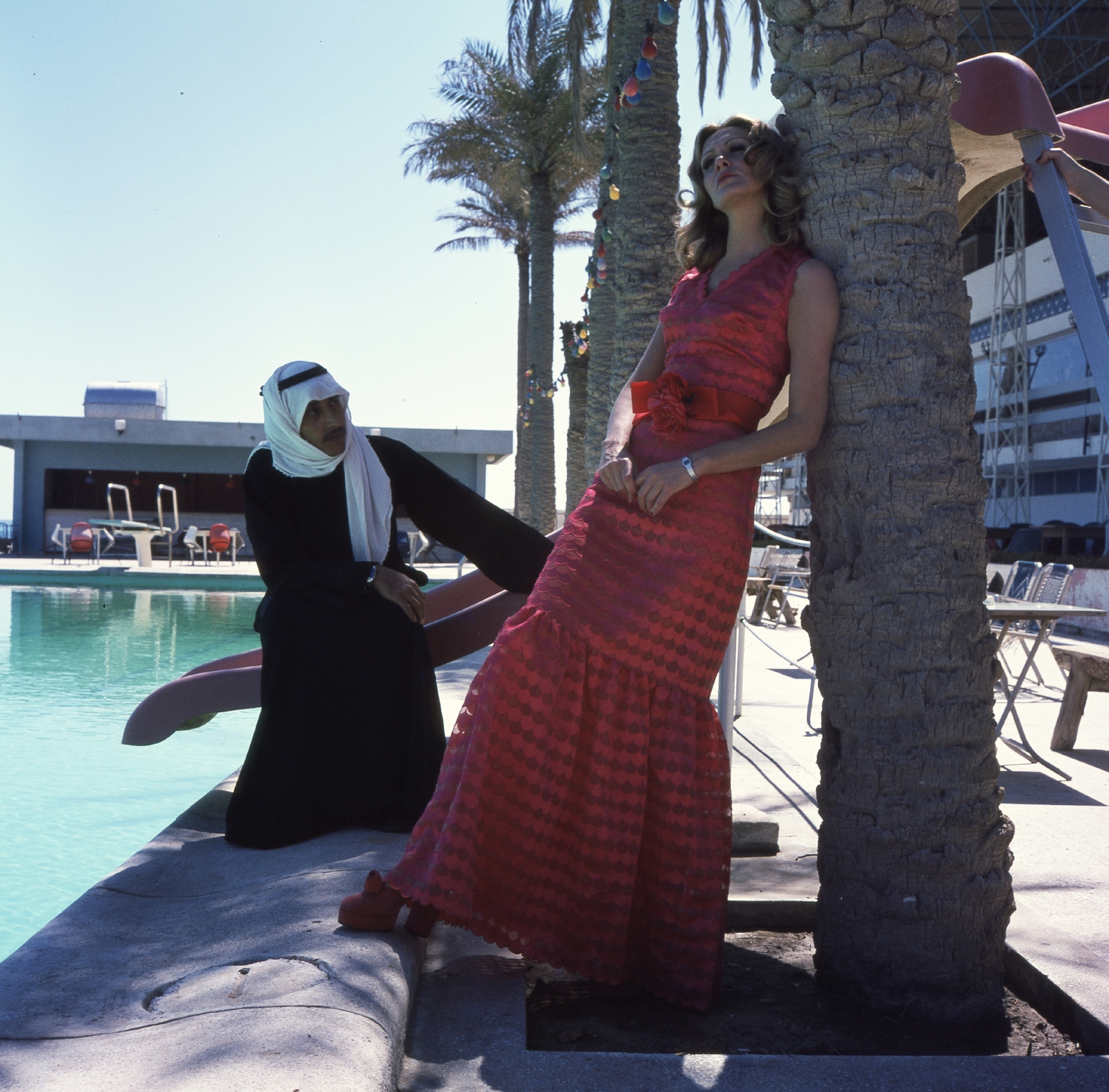 Kuwait, Kuwait City, Zám Edit manöken., 1973, Schiffer Pál, ad, fashion, pool, swimming pool, colorful, love, wrist watch, palm tree, curiosity, lady, summer dresses, maxi dresses, head-gear, water slide, fashion photography, Fortepan #44725