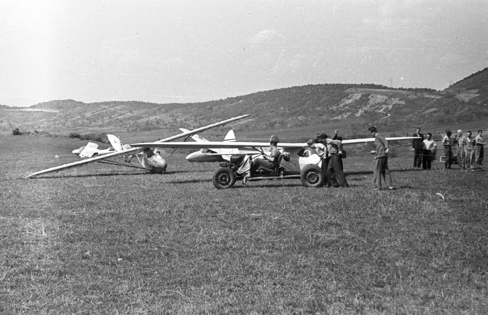 Hungary, Hármashatárhegy Airport, Budapest II., előtérben a "Krehács" becenevű csörlőkötél vontató. Háttérben többek közt: Vöcsök, Cinke, Pilis és Koma típusú vitorlázó repülőgépek., 1957, Mészáros Zoltán, Hungarian brand, airport, sailplane, Budapest, Fortepan #44936