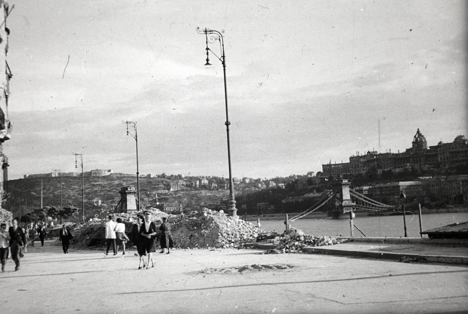 Hungary, Budapest V., Széchenyi rakpart, háttérben a lerombolt Széchenyi Lánchíd és a romos Királyi Palota (később Budavári Palota)., 1945, Fortepan, picture, wrecked bridge, ruins, lamp post, Budapest, suspension bridge, William Tierney Clark-design, Fortepan #45594