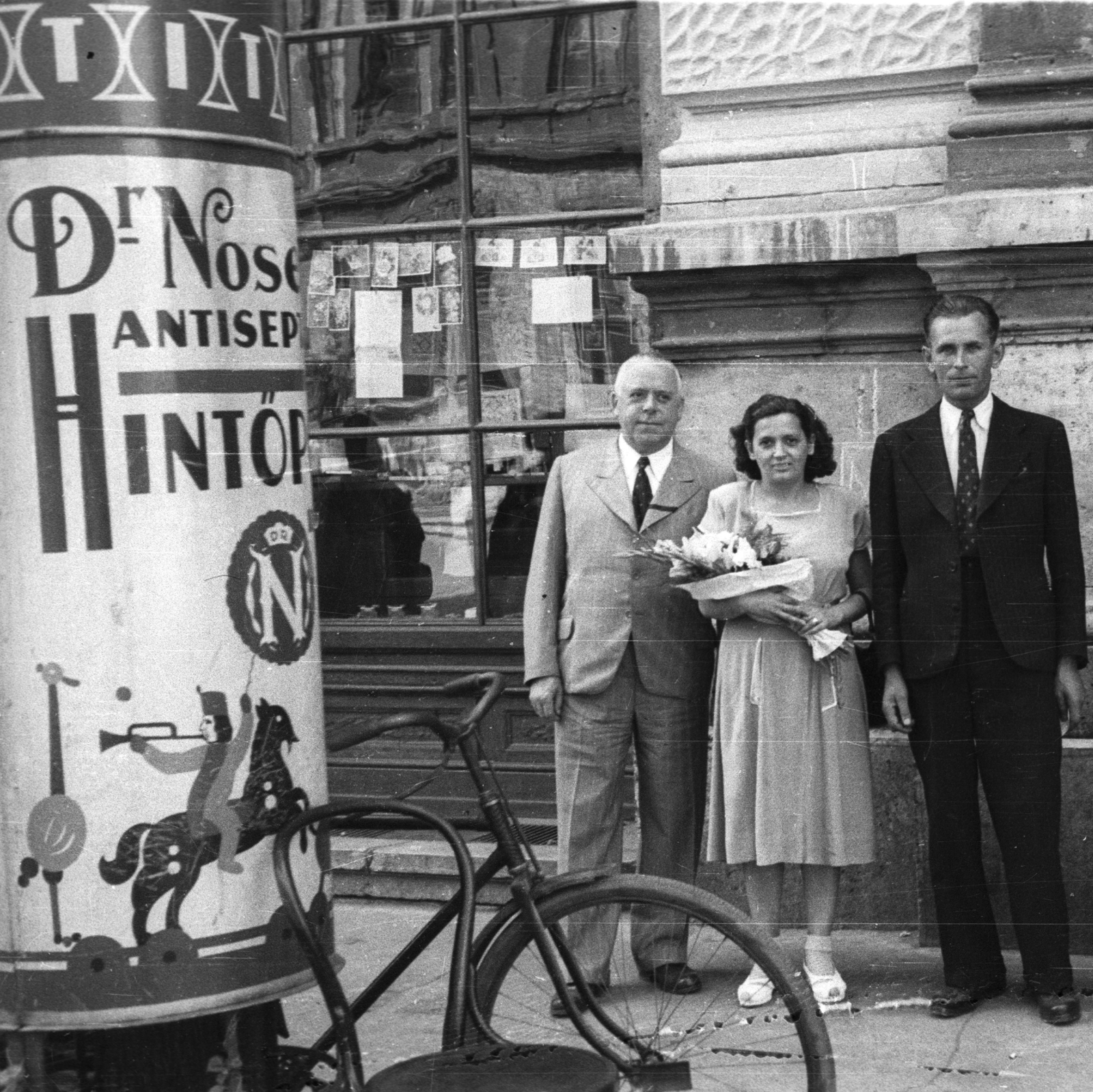 Magyarország, Budapest VIII., Baross utca 63-67., a felvétel a Kerületi Tanács (később Polgármesteri Hivatal) előtt készült., 1953, Krasznai Gyula, reklám, kerékpár, hirdetőoszlop, virág, thonet, szék, Budapest, Fortepan #45813