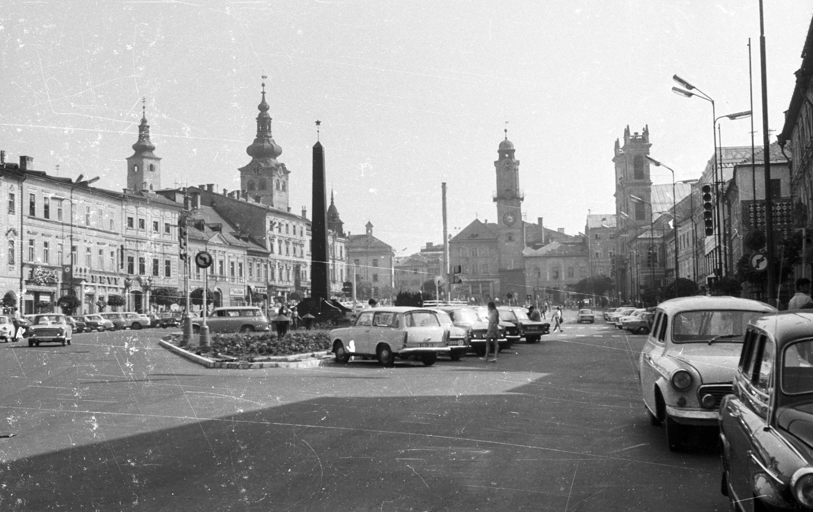 Slovakia, Banská Bystrica, Szlovák Nemzeti Felkelés (Slovenského národného povstania) tér (egykor IV. Béla király tér), szemben az Óratorony, jobbra a Xavéri Szent Ferenc-székesegyház., 1969, Mészáros Zoltán, Czechoslovakia, Czechoslovak brand, German brand, Trabant-brand, Skoda-brand, car park, automobile, Upper Hungary, Soviet memorial, clock tower, Fortepan #46707