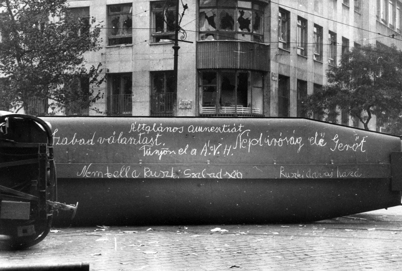 Hungary, Budapest VIII., József körút, felborított villamosok a Népszínház utca torkolatánál. Háttérben a Szabad Nép székháza a Blaha Lujza tér sarkánál., 1956, Pesti Srác2, label, revolution, tram, politics, wreck, damaged building, Trailer car, Budapest, Fortepan #46767
