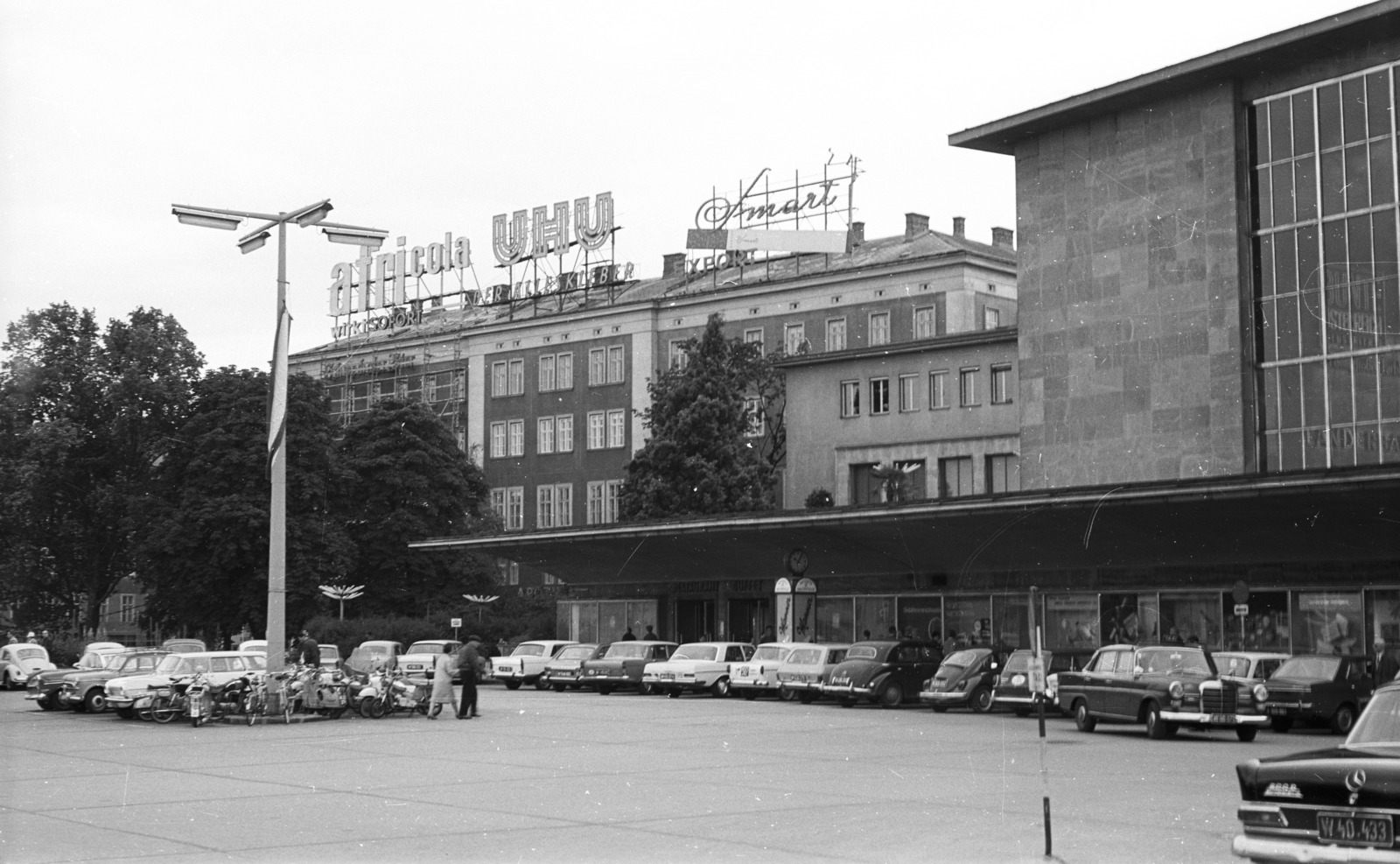 Austria, Vienna, Europaplatz, jobbra a Westbahnhof., 1969, Nagy Gyula, Gerrman brand, street view, neon sign, Mercedes-brand, car park, phone booth, lamp post, train station, scooter, automobile, Fortepan #50086