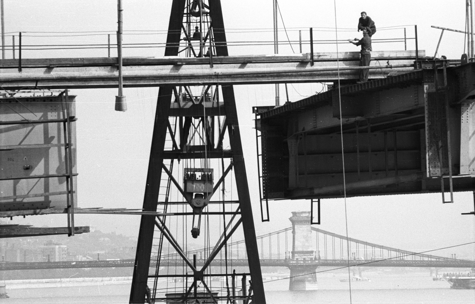 Magyarország, Budapest, az Erzsébet híd építése, az utolsó pályaegység beemelésekor. Háttérben a Széchenyi Lánchíd., 1964, Nagy Gyula, daru, hídépítés, munka, Duna, függőhíd, Duna-híd, William Tierney Clark-terv, Fortepan #50613