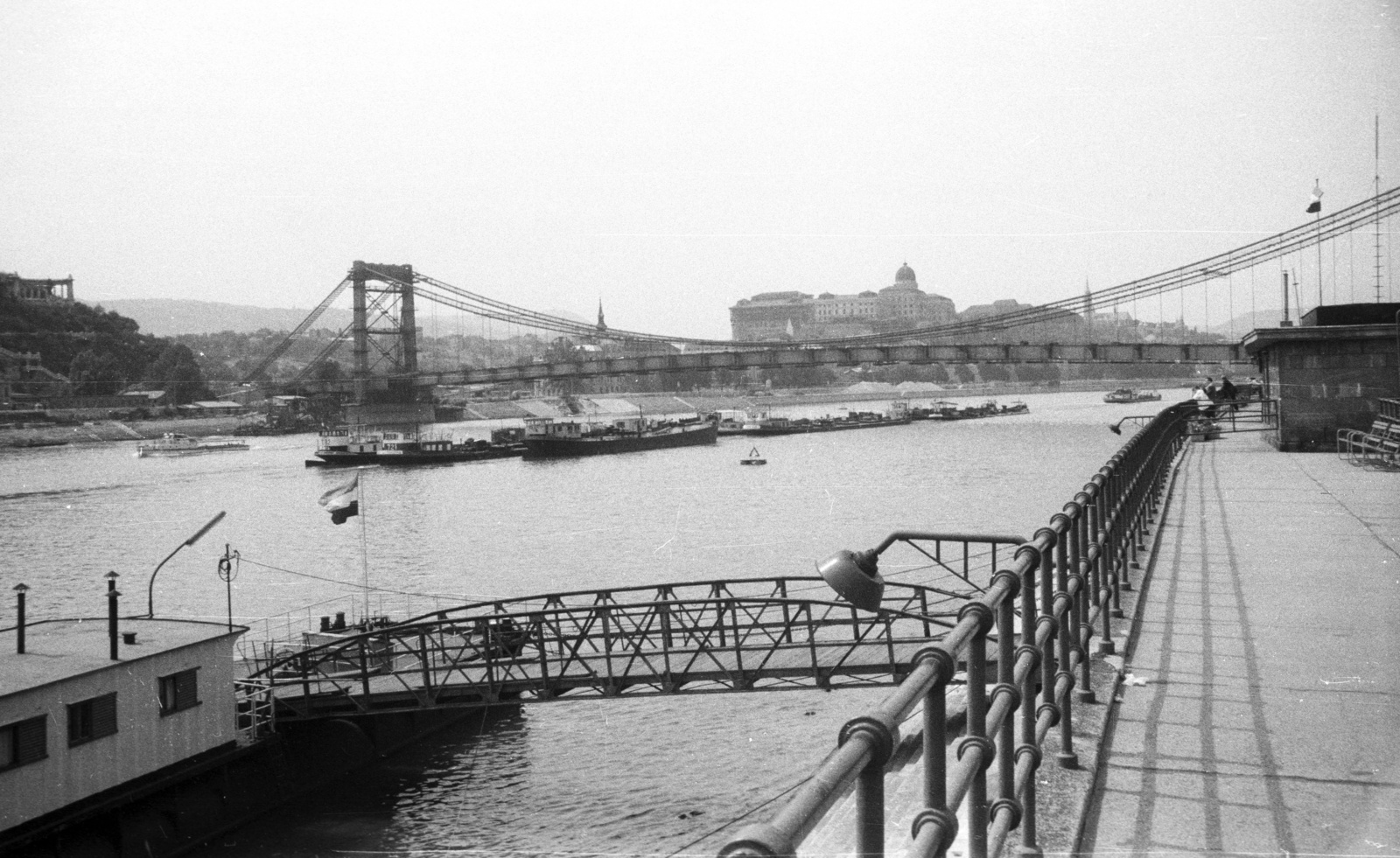 Hungary, Budapest V., az épülő Erzsébet híd a Belgrád rakparti hajóállomástól nézve. Háttérben a budai Vár., 1964, Nagy Gyula, ship, barge, bridge building, boat station, Budapest, Duna-bridge, Fortepan #50628