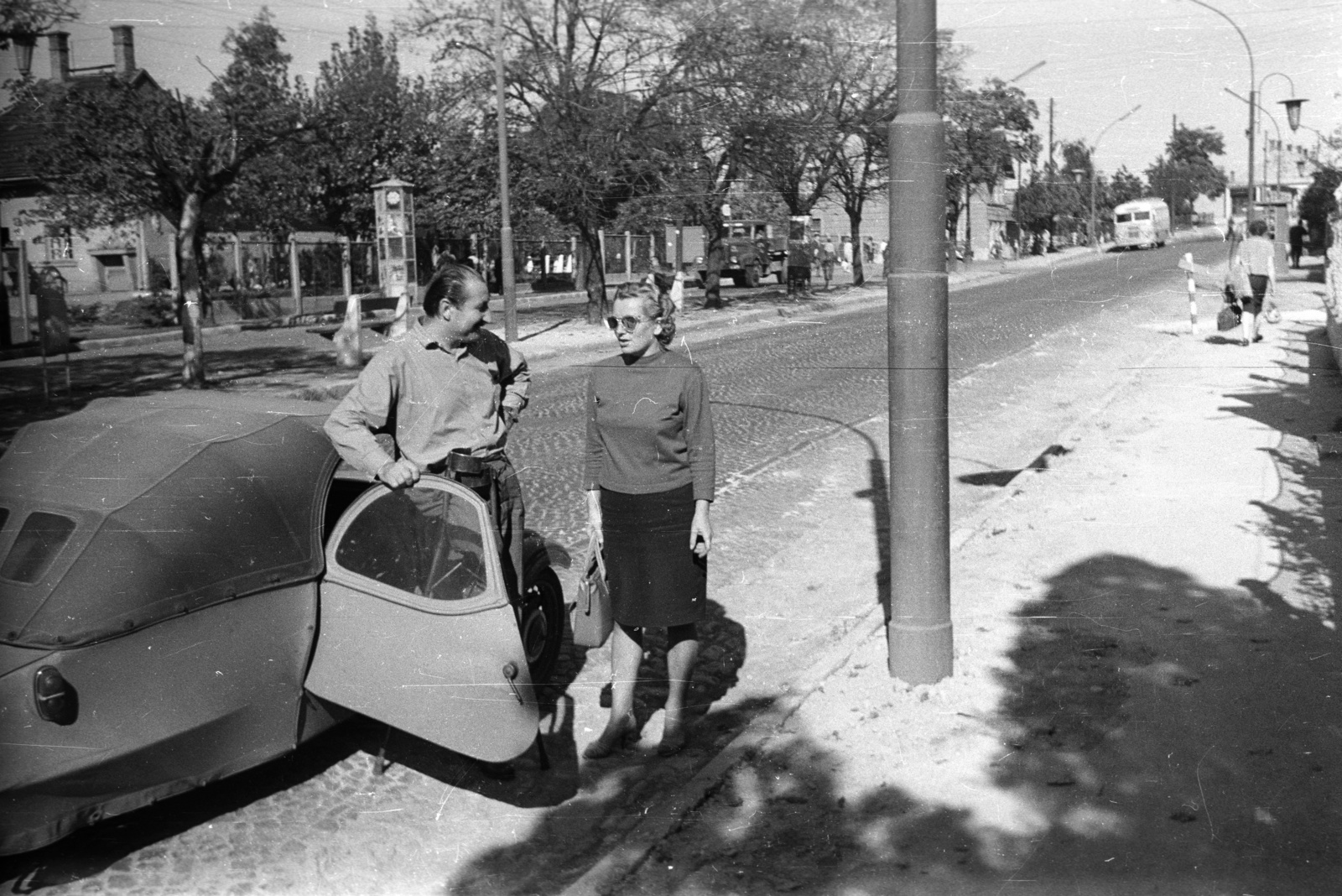 Hungary, Veszprém, Budapest út (Partizán utca), balra a Nagyállomás., 1962, Nagy Gyula, bus, Czechoslovak brand, street view, genre painting, shades, man, handbag, lady, skirt, automobile, Velorex-brand, Fortepan #50992