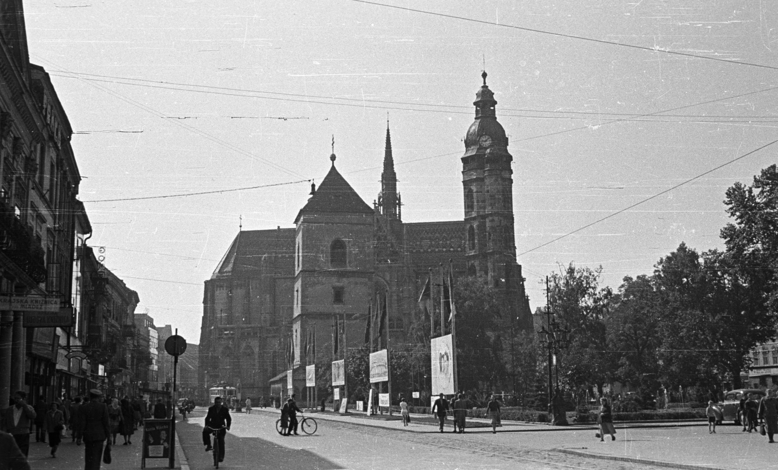 Slovakia, Košice, Fő tér (Hlavné namestie), Szent Erzsébet-főszékesegyház (Dóm), előtte az Orbán-torony., 1956, Nagy Gyula, Czechoslovakia, bicycle, church, pedestrian, tram, political decoration, Catholic Church, tram stop, Upper Hungary, Cathedral, bell tower, Martin Lindtner-design, Fortepan #51524
