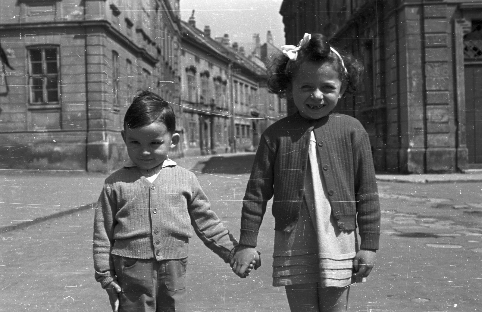 Hungary, Sopron, Templom utca - Kolostor utca sarok, az evangélikus templom előtt., 1957, Nagy Gyula, smile, street view, girl, kid, kids, ribbon, double portrait, hold hands, Fortepan #51724
