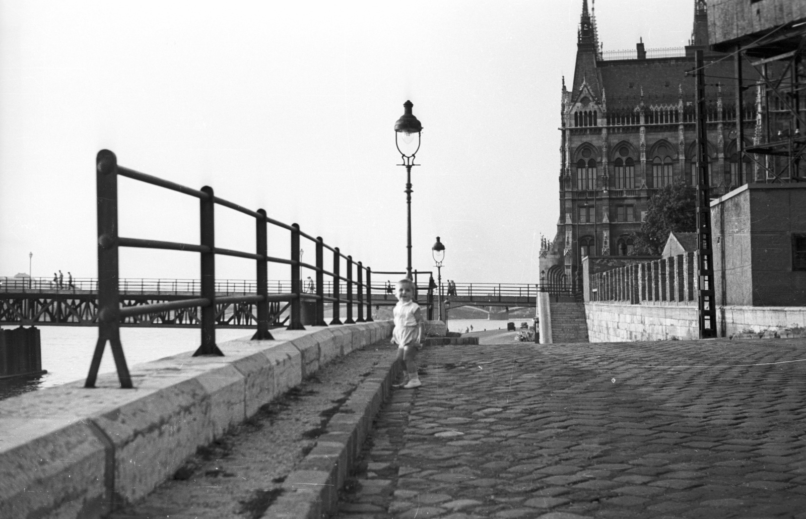 Hungary, Budapest V., Széchenyi rakpart, háttérben a Kossuth híd és az Országház., 1955, Nagy Gyula, bridge, railing, kid, lamp post, Imre Steindl-design, wharf, cobblestones, parliament, Neo-Gothic-style, eclectic architecture, Budapest, Fortepan #51760