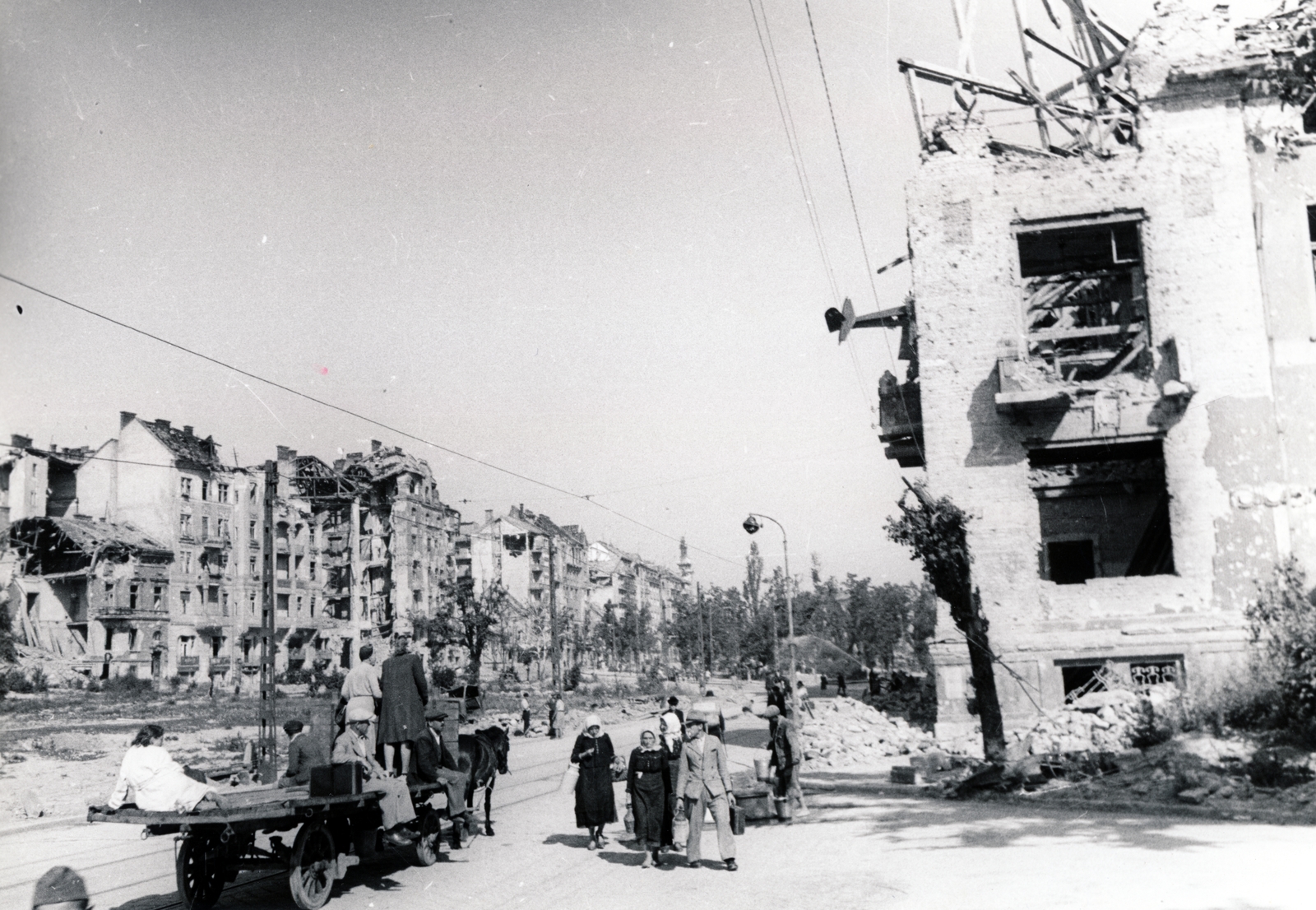 Magyarország, Budapest I., Dózsa György (Palota) tér a Krisztina körút házai felé nézve. Fenn az Attila út 35. (Attila körút 2.) számú épületbe csapódott vitorlázó repülőgép., 1945, Fortepan, háborús kár, lovaskocsi, utcakép, életkép, járműroncs, fogat, rom, lámpaoszlop, sokaság, vitorlázó repülőgép, Budapest, DFS 230, Fortepan #52092