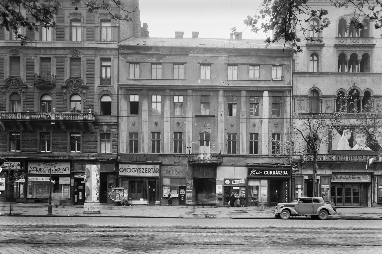 Magyarország, Budapest VIII., Rákóczi út 23., jobbra a 21., az Uránia mozi épülete., 1957, UVATERV, plakát, cégtábla, hirdetőoszlop, gyógyszertár, cukrászda, mozi, automobil, Opel Super 6, eklektikus építészet, Budapest, optikus, Henrik Schmahl-terv, golyónyom, Fortepan #5278