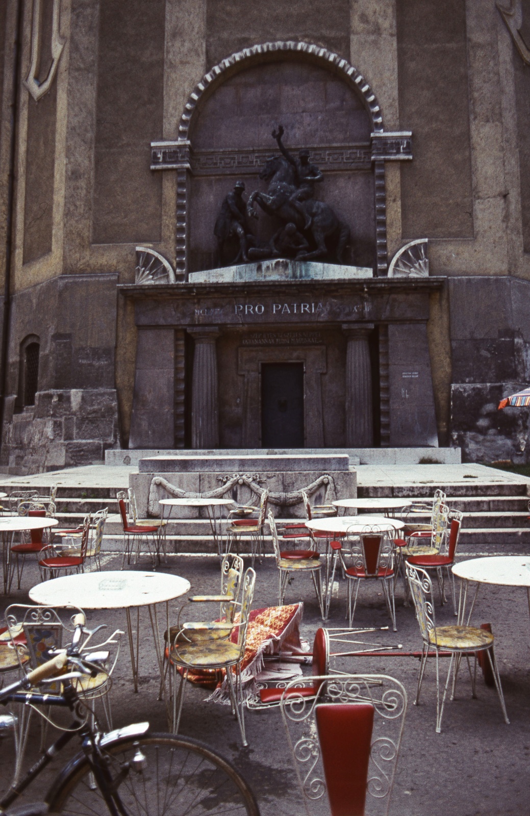 Magyarország, Székesfehérvár, Hősök tere, Szent István-székesegyház, az altemplom bejárata. I. világháborús hősi emlékmű., 1975, Balázs Lajos, kerékpár, templom, színes, felirat, szék, kerti bútor, Fortepan #53306