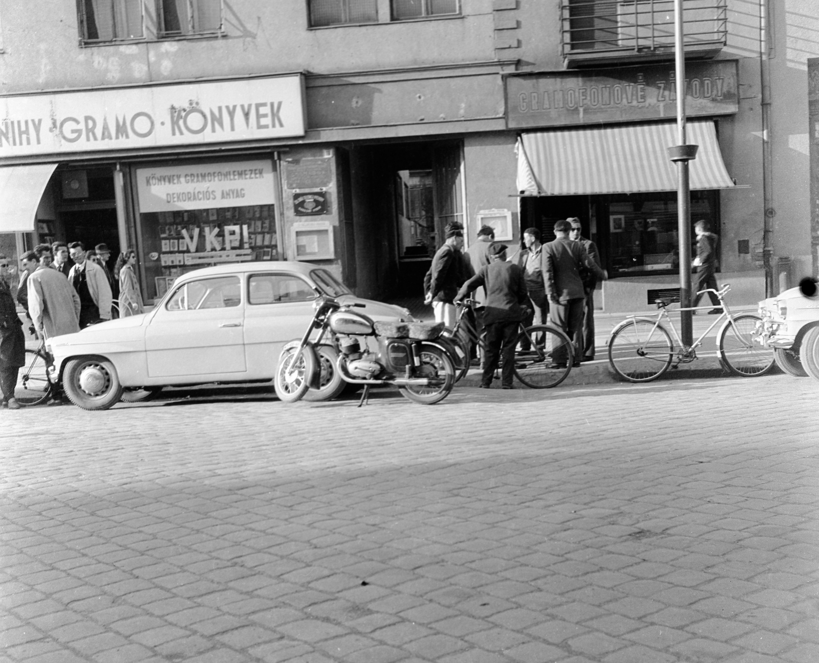 Szlovákia, Losonc, ulica Tomása Garrigue Masaryka 19., 1959, Zsanda Zsolt, Vajszada Károly, Csehszlovákia, kerékpár, motorkerékpár, könyvesbolt, Skoda-márka, automobil, Skoda Octavia, Jawa-márka, napellenző, kétnyelvű felirat, utcakép, Fortepan #53726