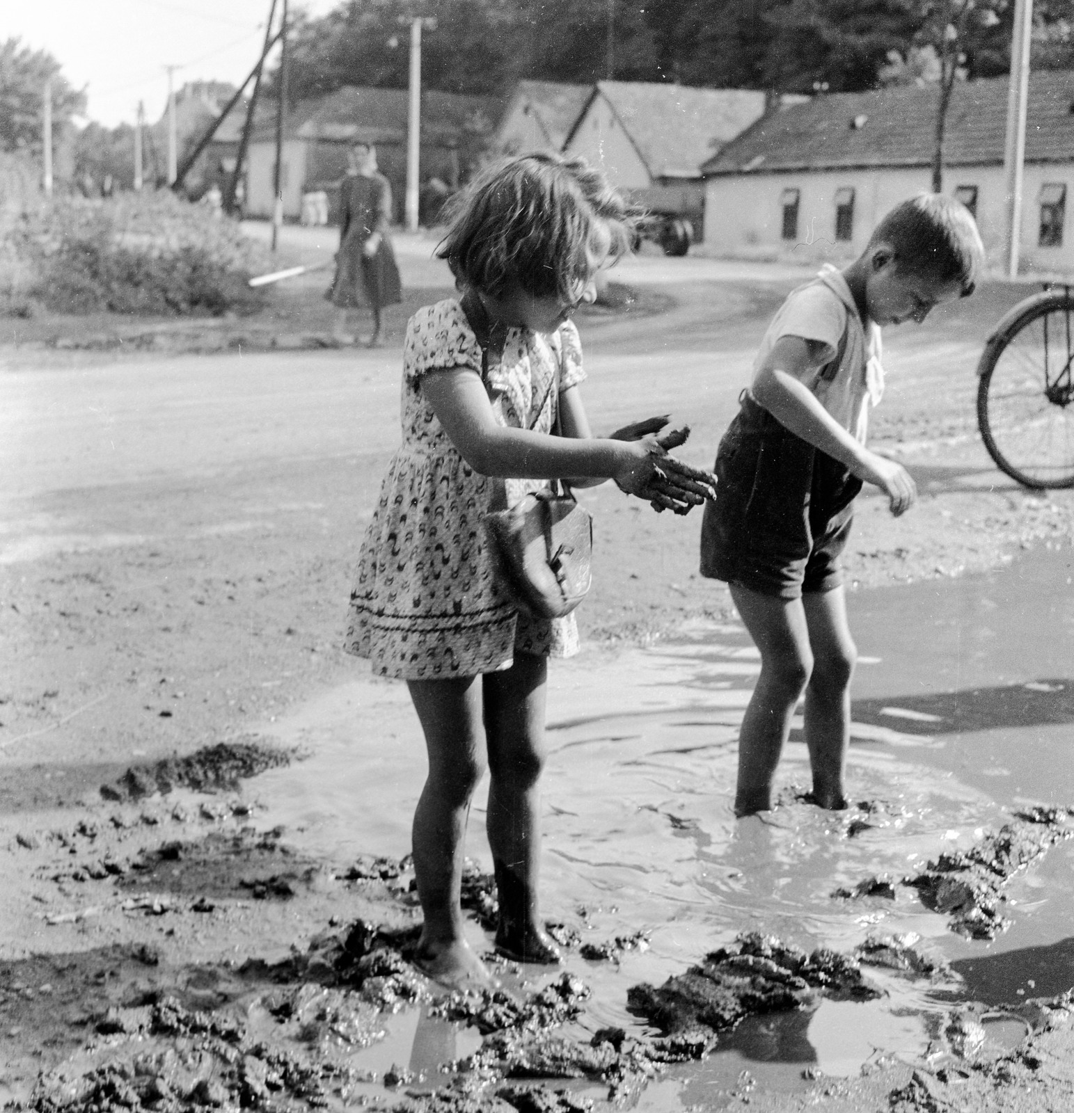 Slovakia, Fiľakovo, ulica Továrenská (Gyári utca), szemben az ulica Slovenského národného povstania (Szlovák Nemzeti Felkelés)., 1959, Zsanda Zsolt, Vajszada Károly, Czechoslovakia, puddle, kids, Fortepan #53788