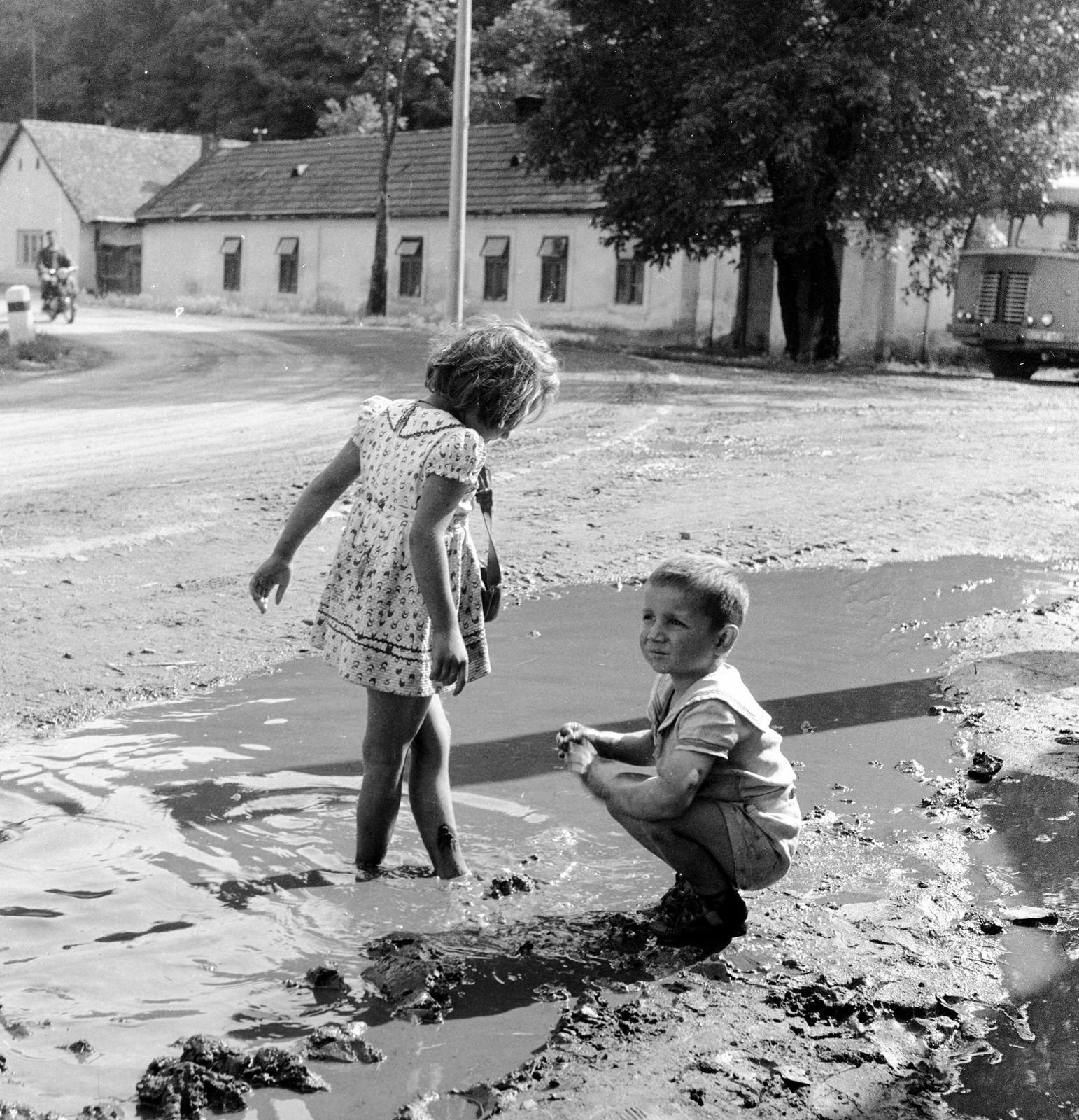 Szlovákia, Fülek, ulica Továrenská (Gyári utca), szemben az ulica Slovenského národného povstania (Szlovák Nemzeti Felkelés) eleje., 1959, Zsanda Zsolt, Vajszada Károly, Csehszlovákia, autóbusz, pocsolya, gyerekek, Fortepan #53789